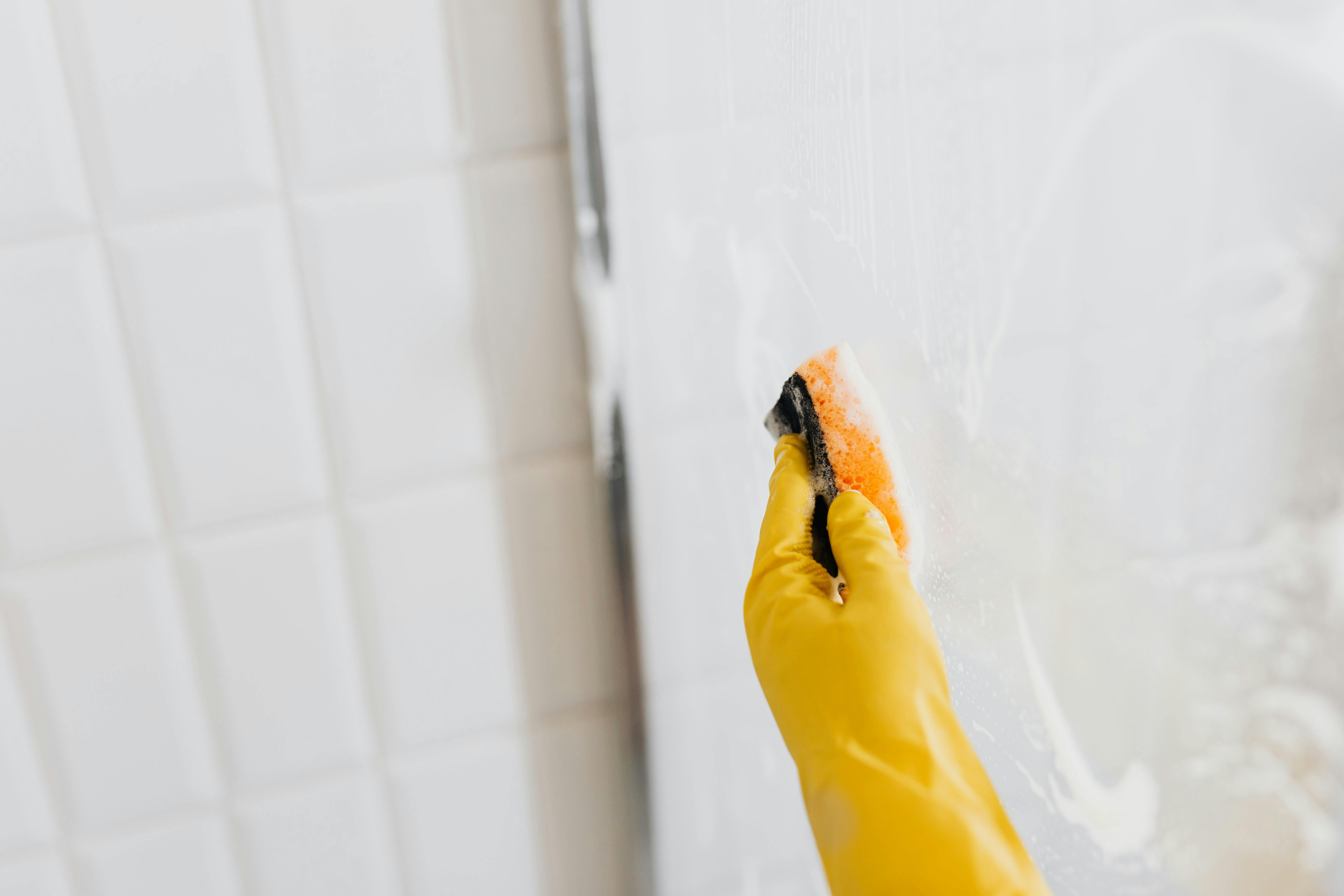 Scrubbing a shower enclosure | Source: Pexels