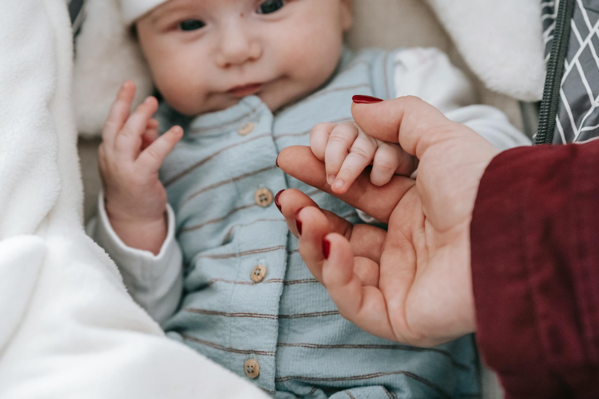 A cute baby holding his mother's hand | Source: Pexels
