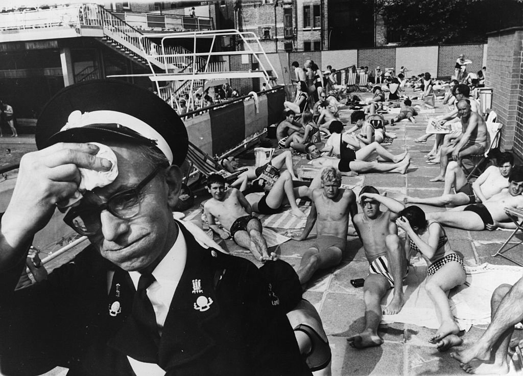 An ambulance man on duty at the Holborn Oasis swimming pool, London, suffering in the July heat | Source: Getty Images
