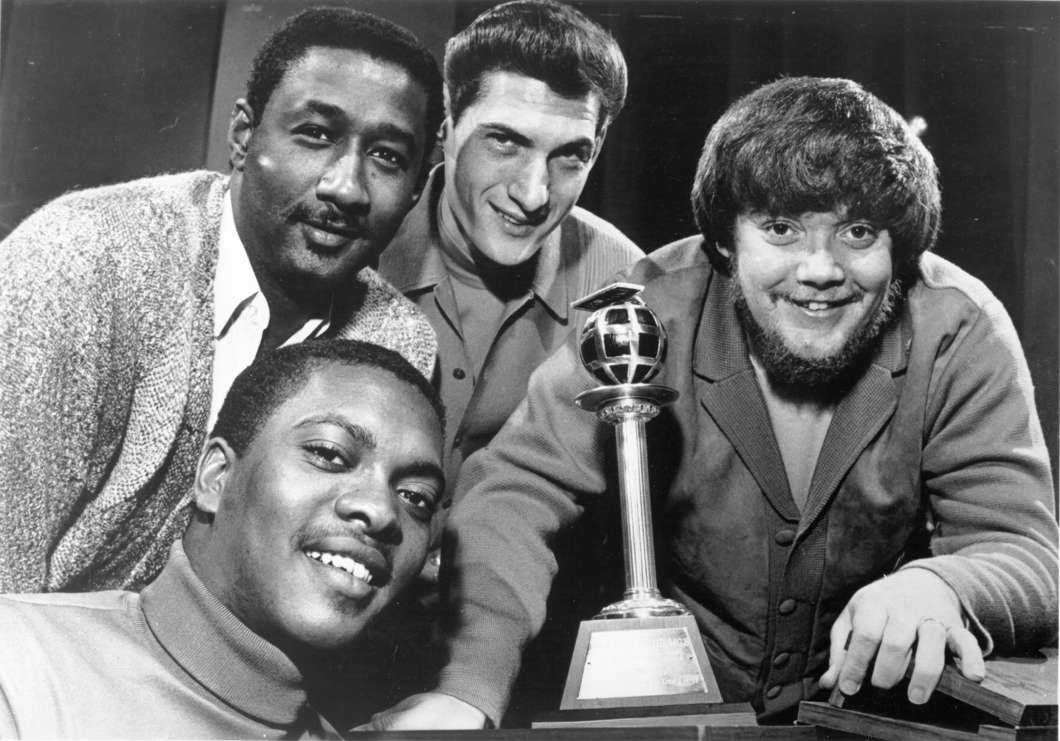 (Clockwise from bottom left) Booker T. Jones, Al Jackson, Steve Cropper and Donald 'Duck' Dunn of the R&B band Booker T. & The M.G.'s pose for a portrait with an award in circa 1964. | Source: Getty Images
