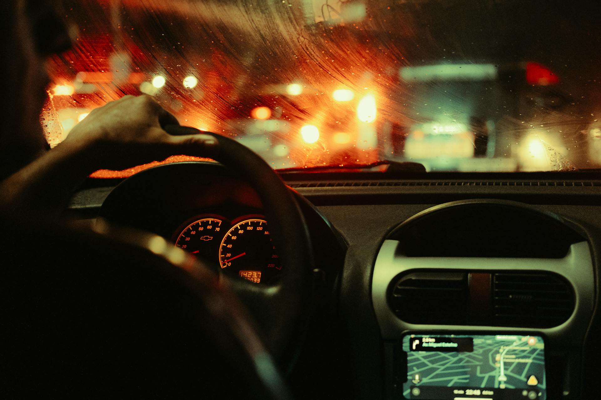 Close-up rear shot of a man driving a car at night | Source: Pexels