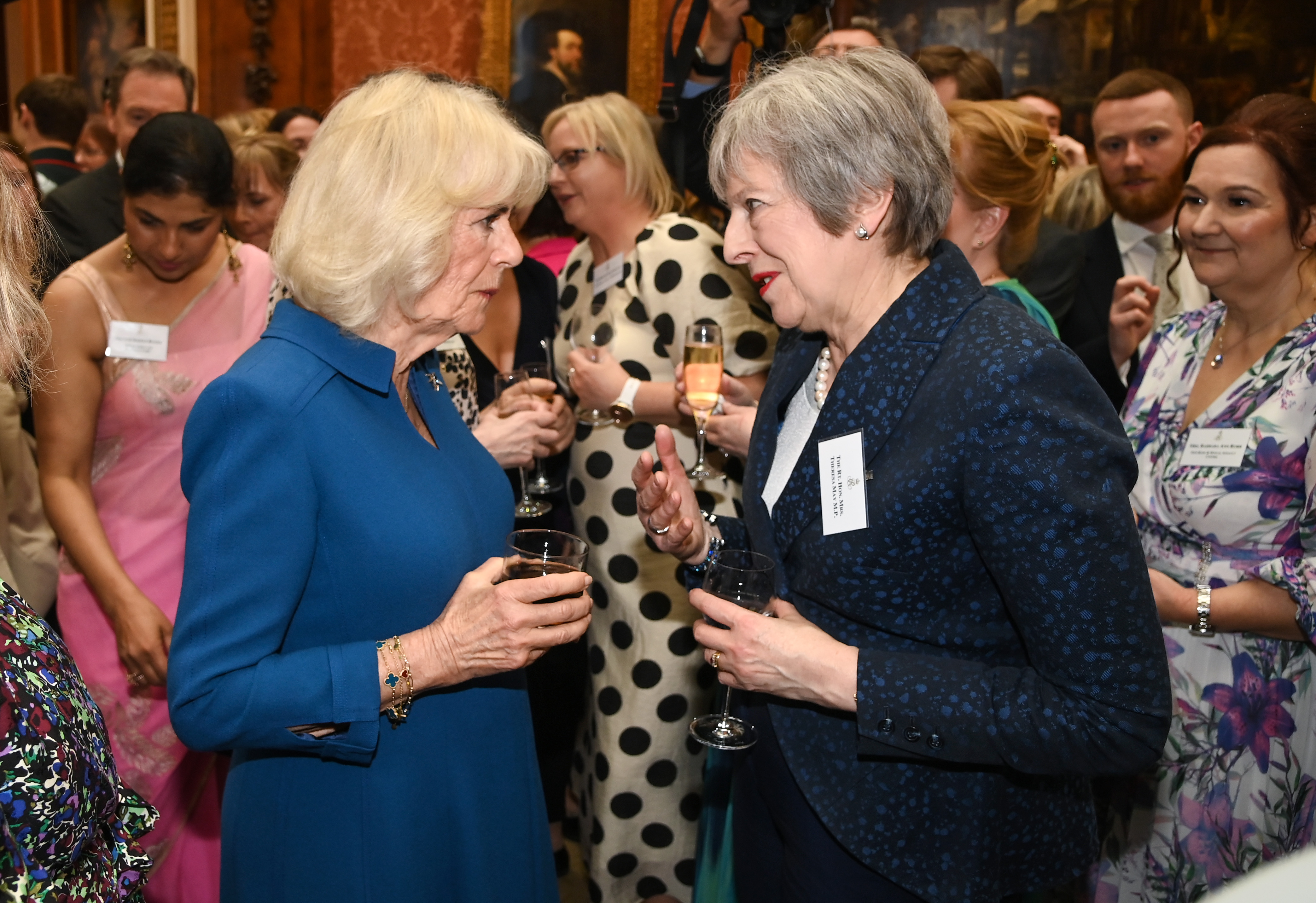 Queen Camilla interacts with former Prime Minister Theresa May as she hosts a reception recognizing those who support survivors of sexual assault at Buckingham Palace in England on May 1, 2024 | Source: Getty Images