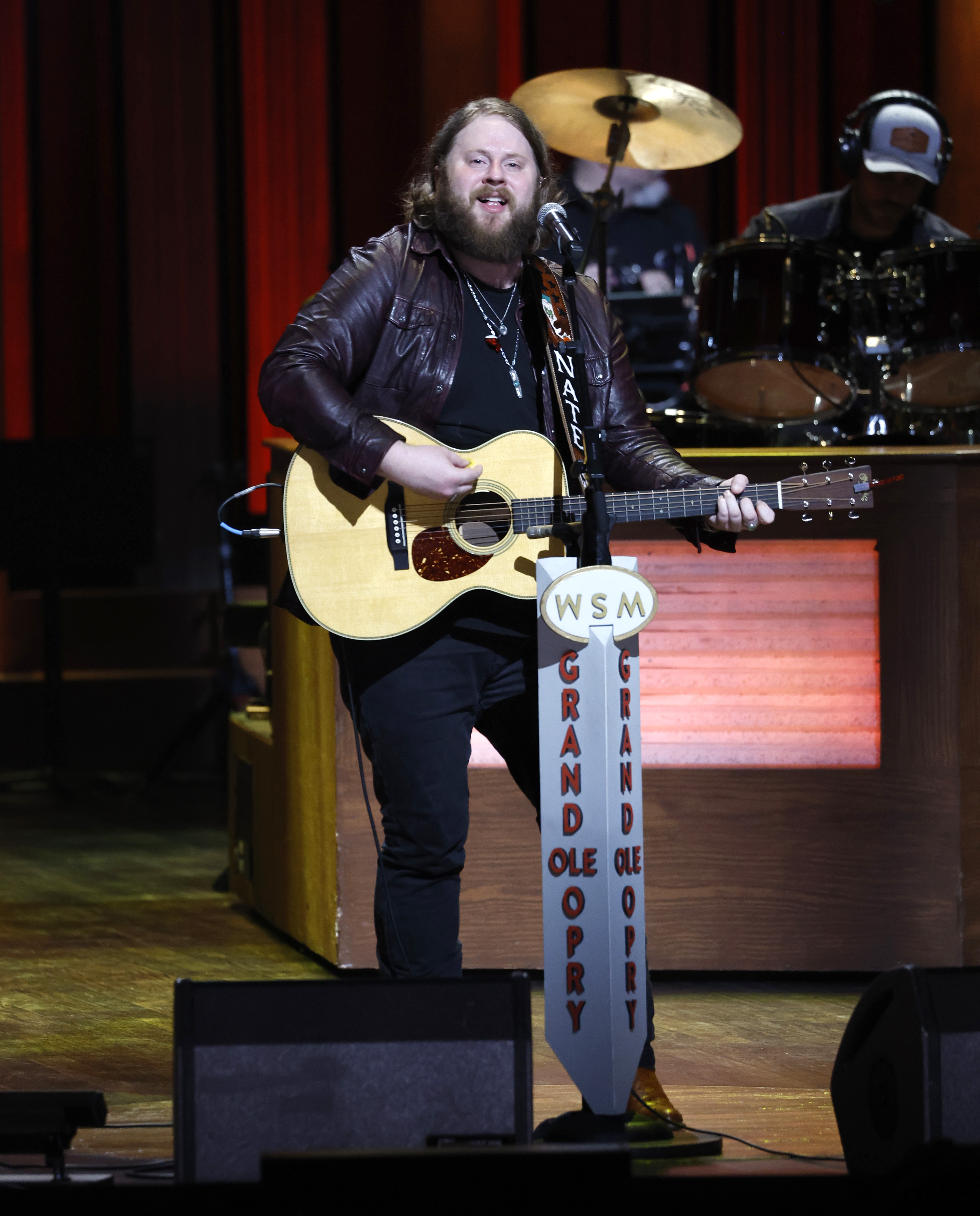 Nate Smith performs with his guitar at the Grand Ole Opry, offering a glimpse of his appearance before the country singer embarked on the health journey that would see him shed more than 70 pounds. | Source: Getty Images