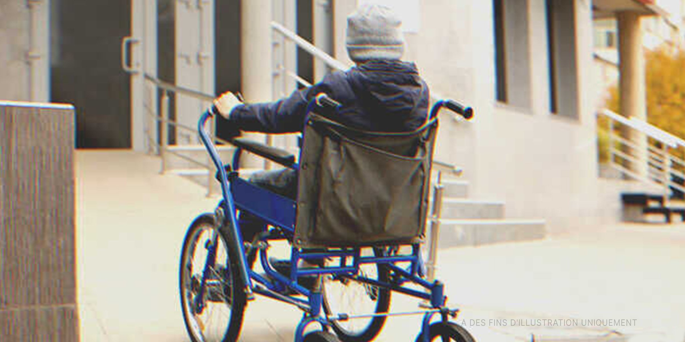 Un garçon en fauteuil roulant à l'extérieur d'un bâtiment | Source : Shutterstock