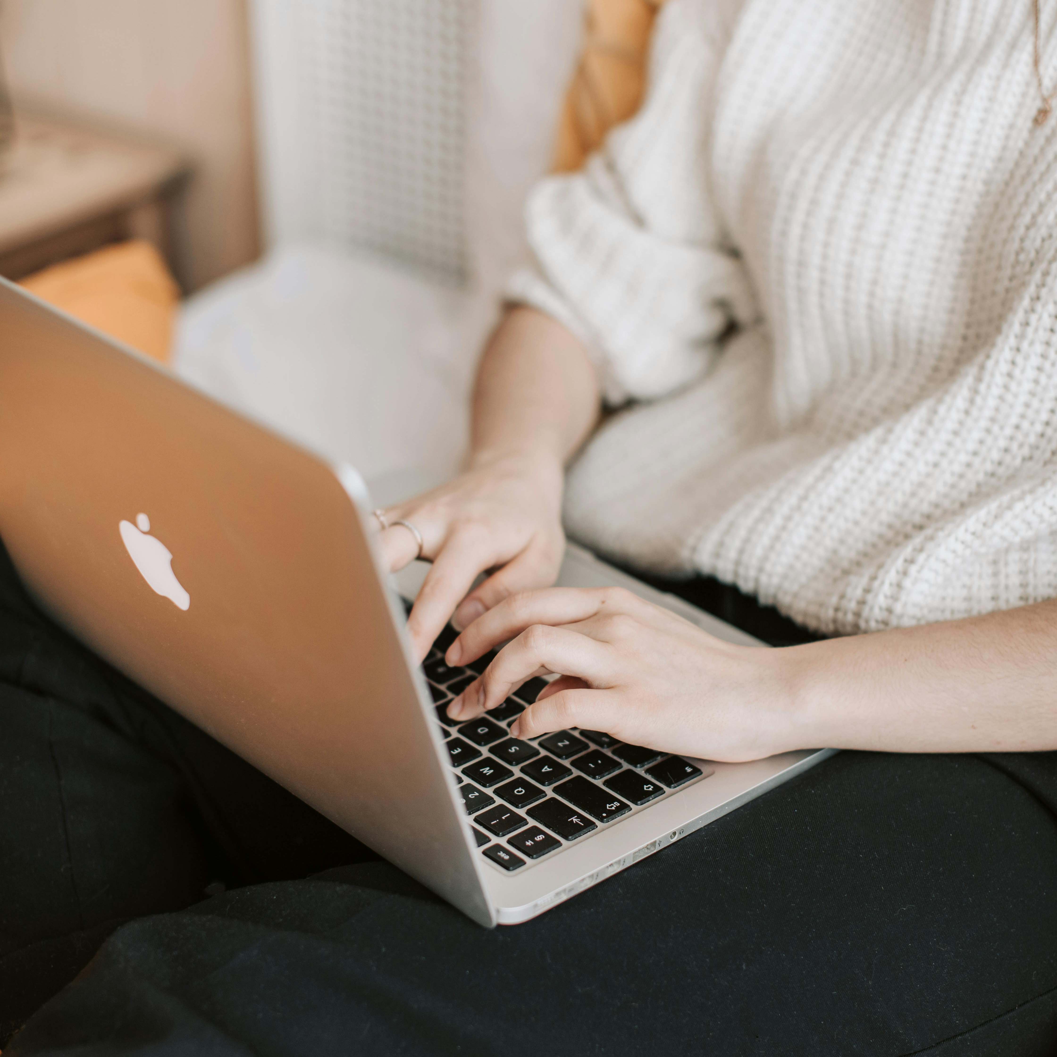 A woman sitting up in bed, working on a laptop | Source: Pexels