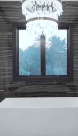 A view of the window and chandelier that sits inside one of the bathrooms inside Kyle and Samantha Busch's family home. | Source: Instagram/rowdybusch