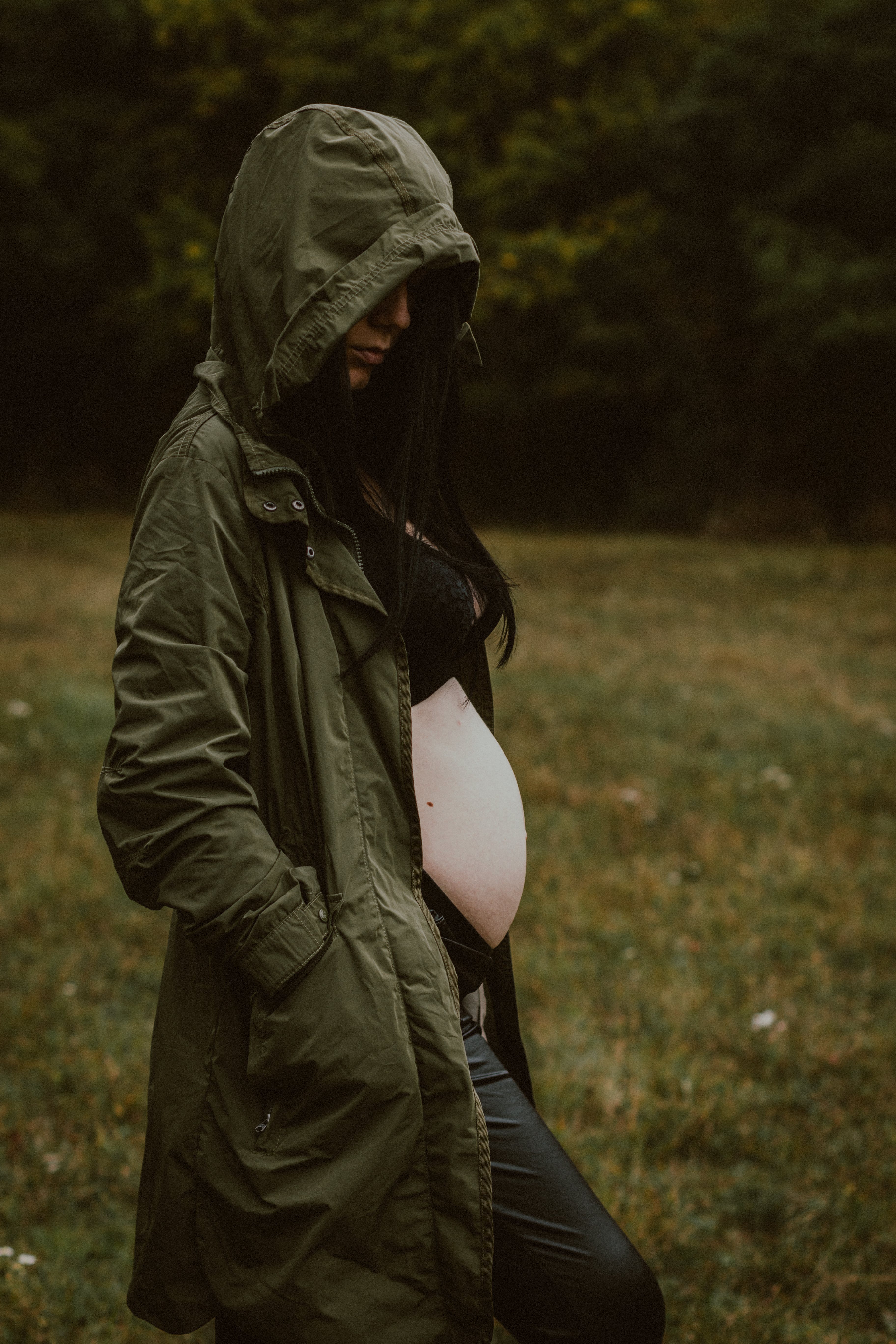 A pregnant woman wearing a green hooded coat. | Source: Pexels