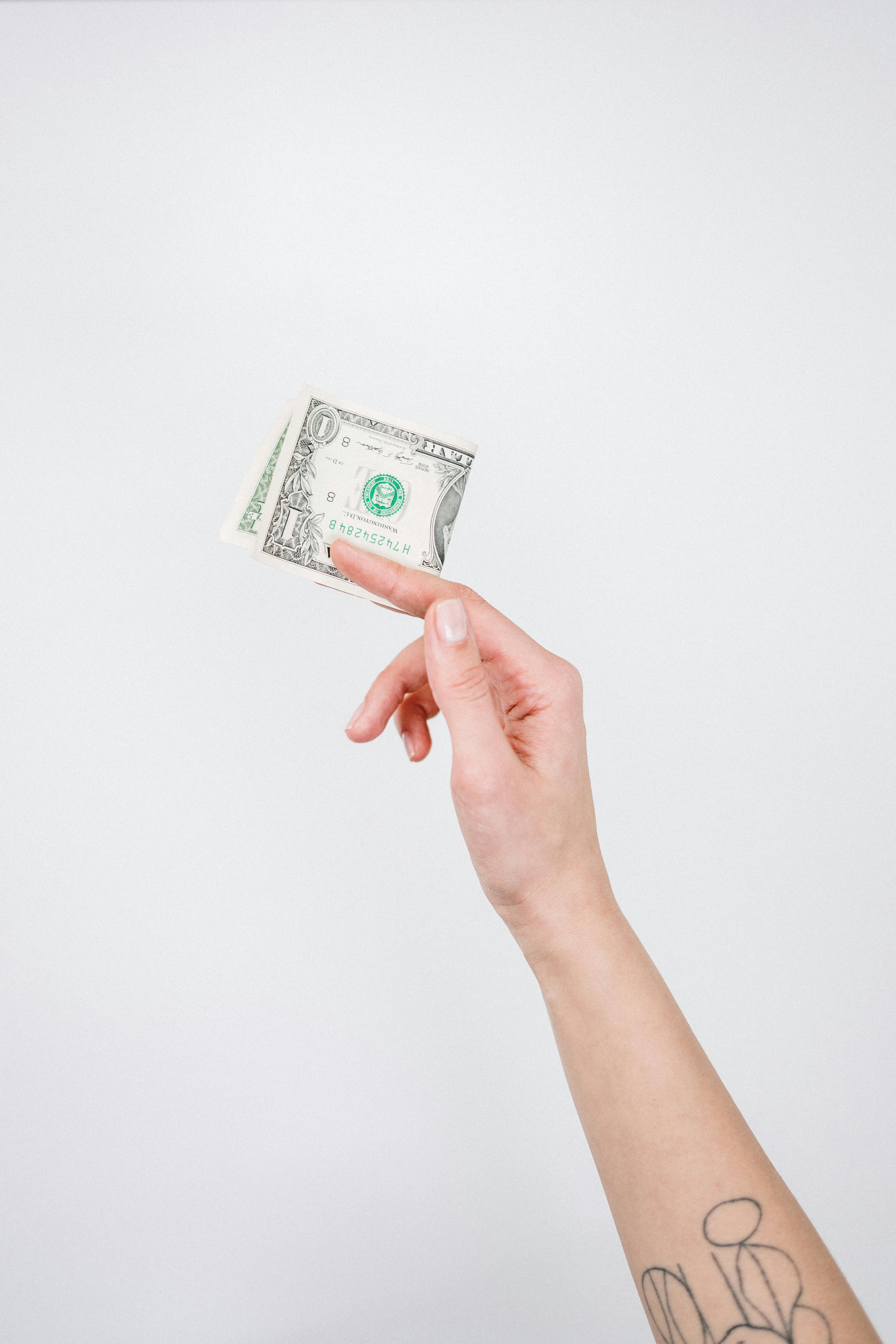 A hand holding a single bill | Source: Pexels