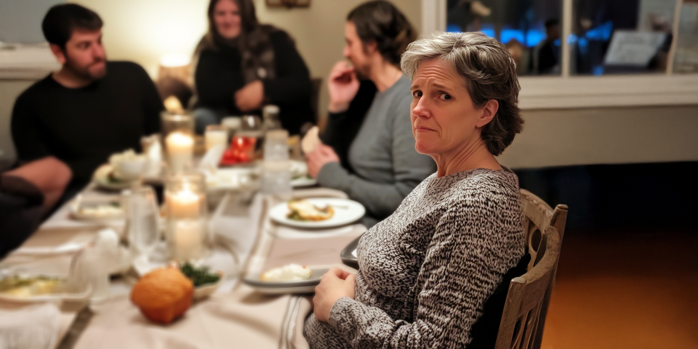 An older woman sitting with her family | Source: AmoMama