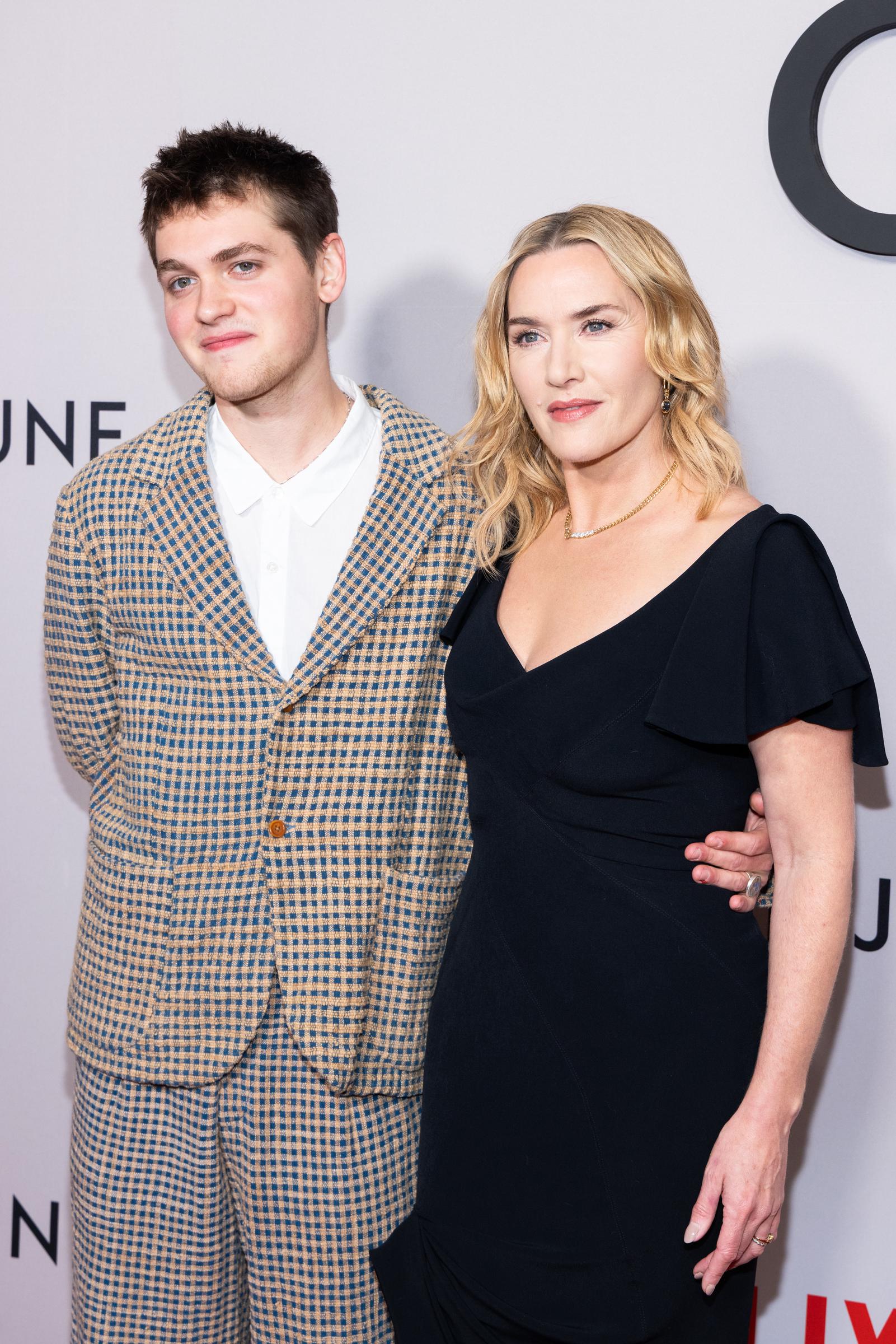 Joe Anders and Kate Winslet posed together at Netflix's "Goodbye June" screening in New York on December 8, 2025, marking their second major red carpet appearance in less than a week. Anders opted for a bold checkered suit that contrasted with Winslet's sleek black ensemble, as the pair continued their promotional run for the deeply personal drama.