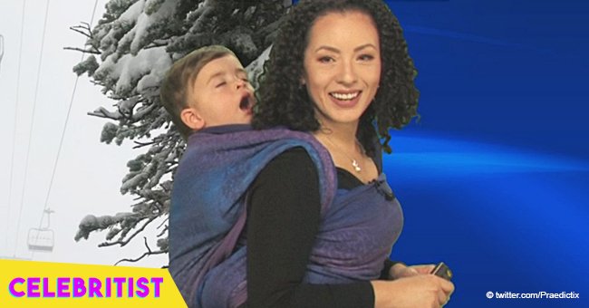 Meteorologist wears toddler son on her back during forecast 