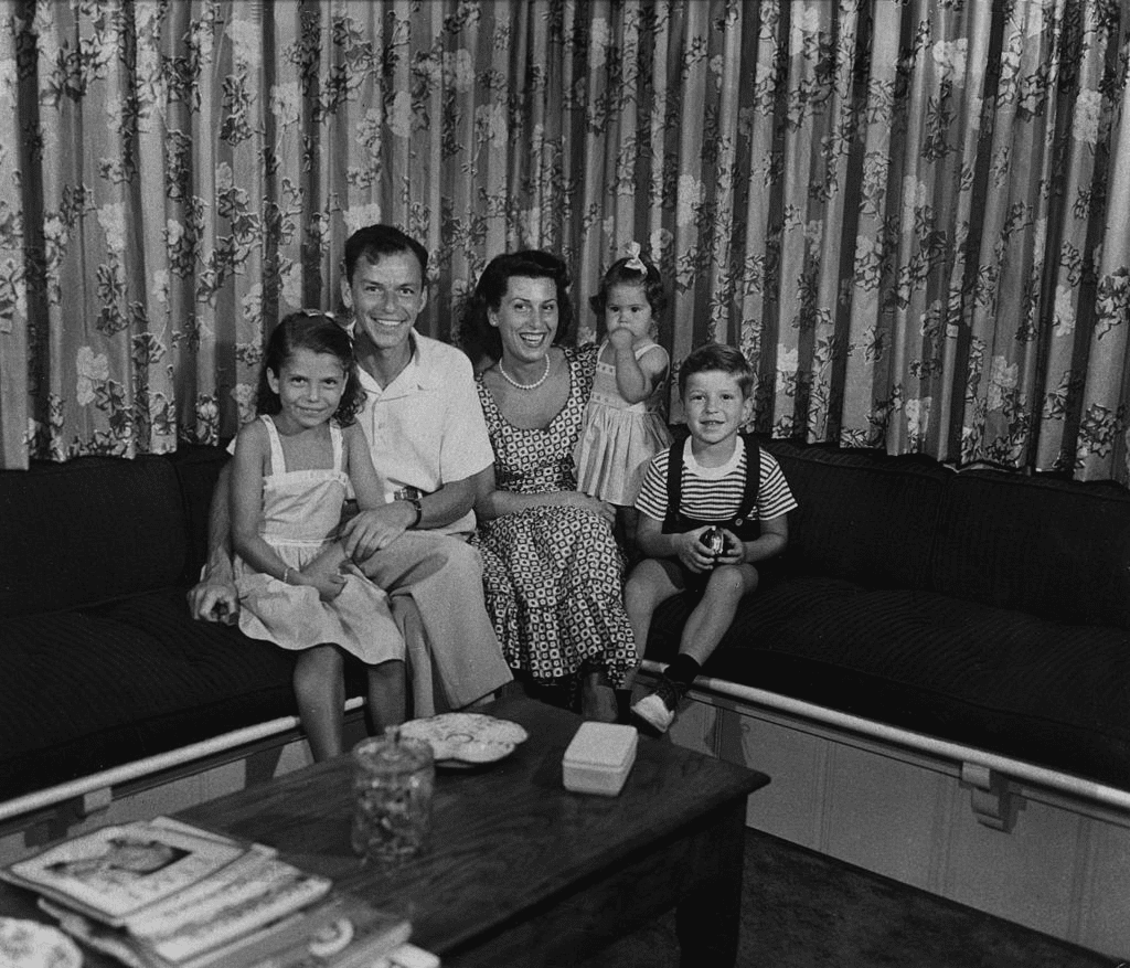 Vers 1950 : Portrait de famille du chanteur et acteur américain Frank Sinatra (1915-1989) assis sur un canapé avec sa première femme, Nancy Barbato, et leurs enfants Nancy, Tina, et Frank Jr. | Photo : Getty Images