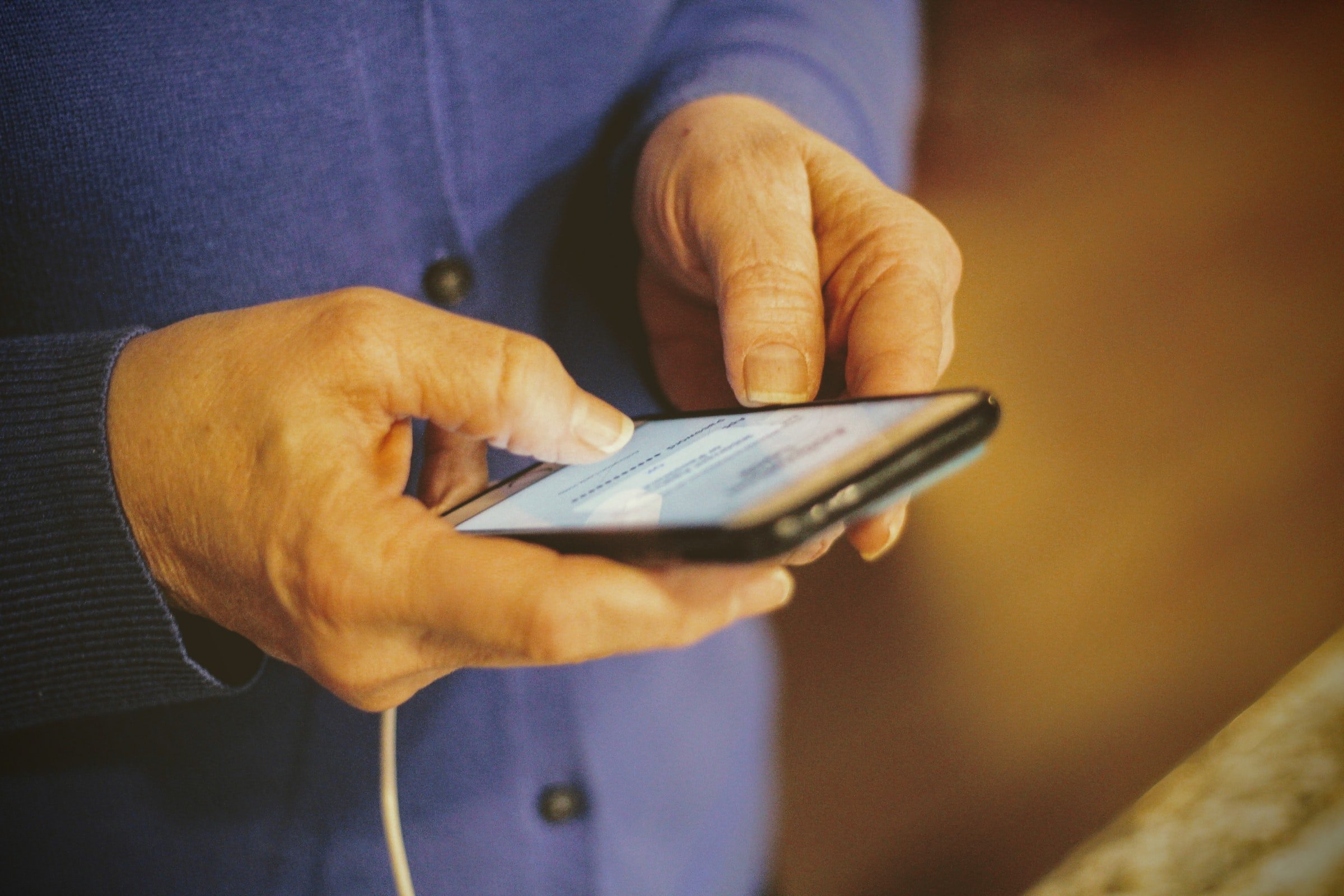 Woman holding a phone in her hands. | Source: Unsplash