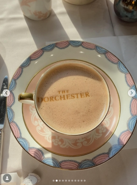 A frothy latte served in The Dorchester's signature china, its gold-rimmed saucer trimmed in soft pink and blue, with the hotel's name printed directly onto the surface of the drink. It is a small but telling detail that speaks to the kind of afternoon Osbourne had in store for her son. | Source: Instagram/kellyosbourne