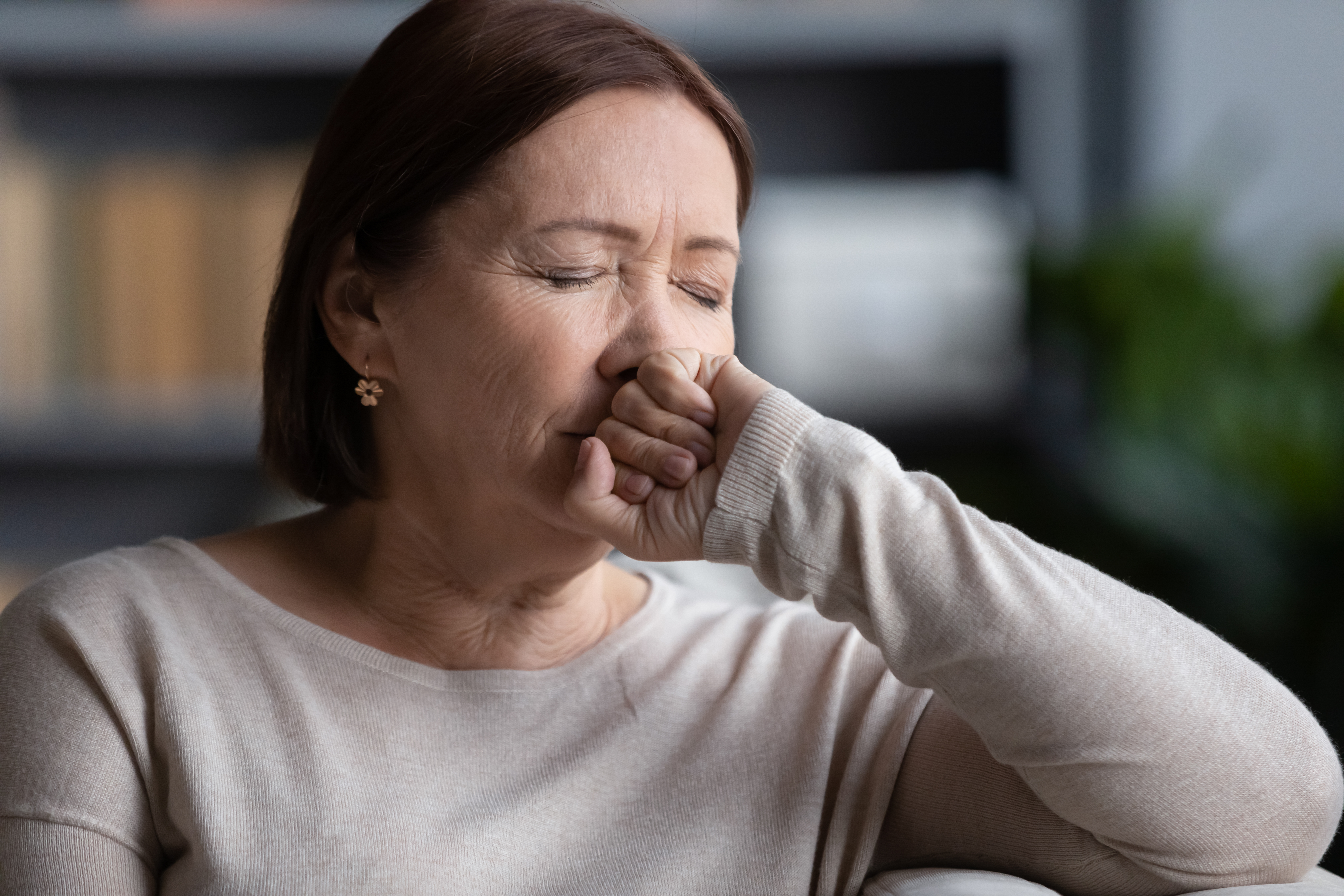 A stressed woman sitting with her eyes closed | Source: Shutterstock