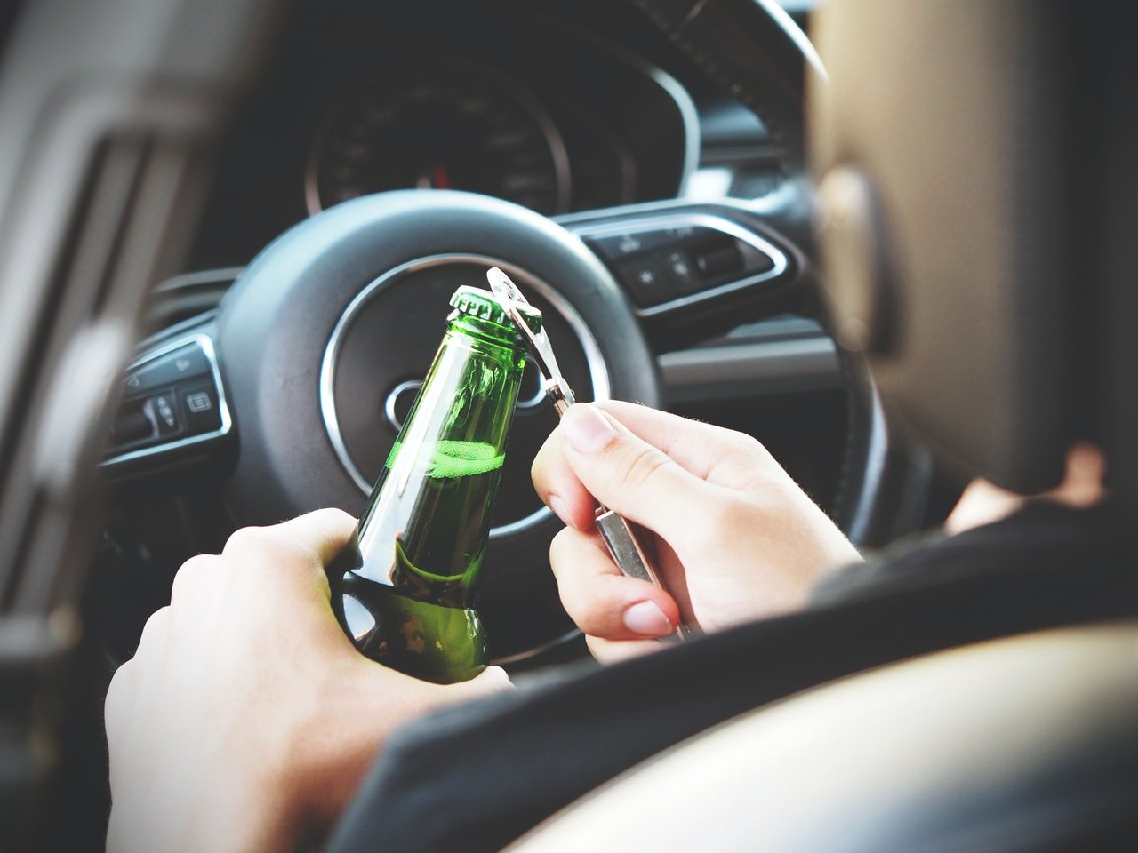 Autofahrer öffnet Bierflasche | Quelle: energepic.com/Pexels