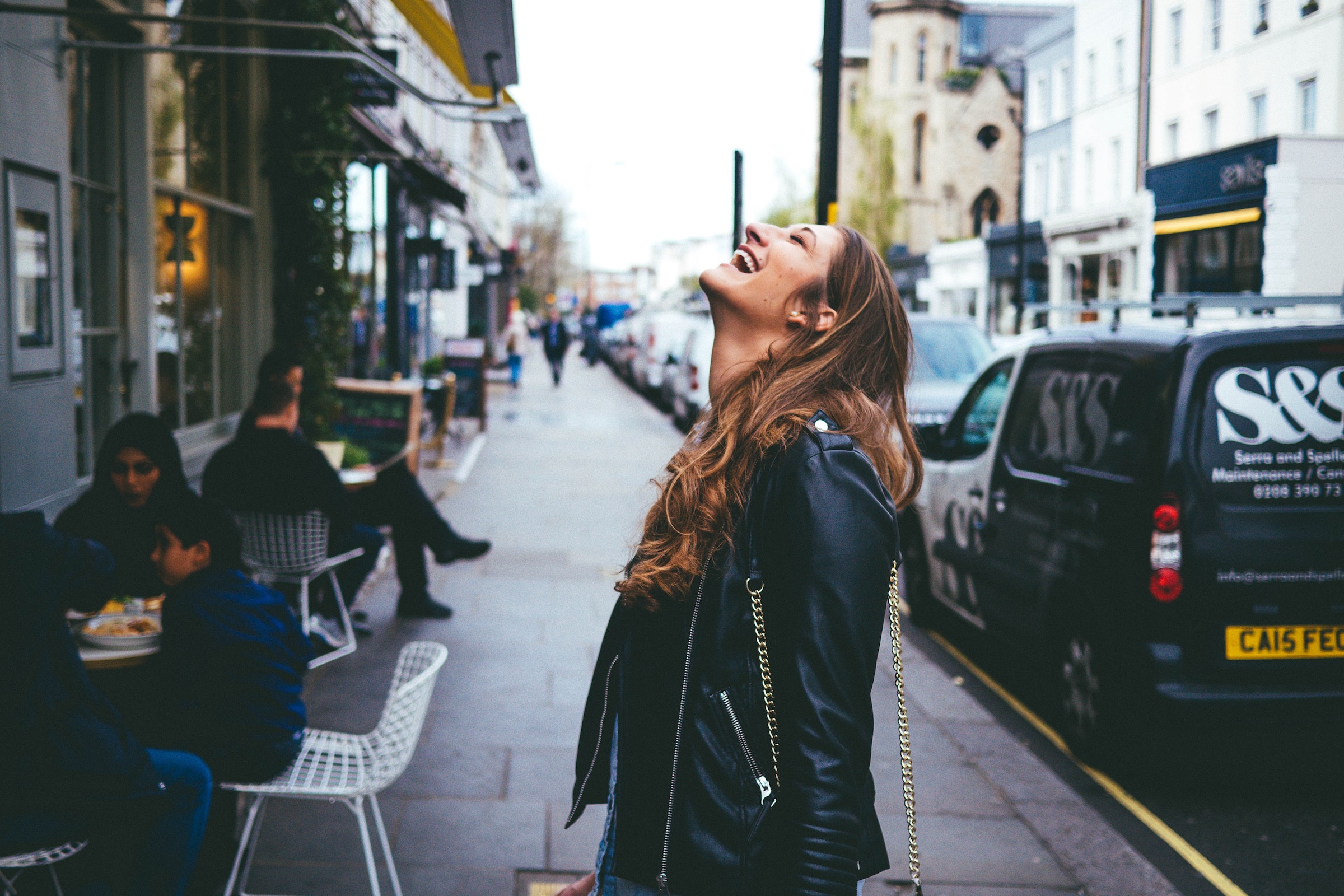 Woman laughing on a street. | Source: Unsplash
