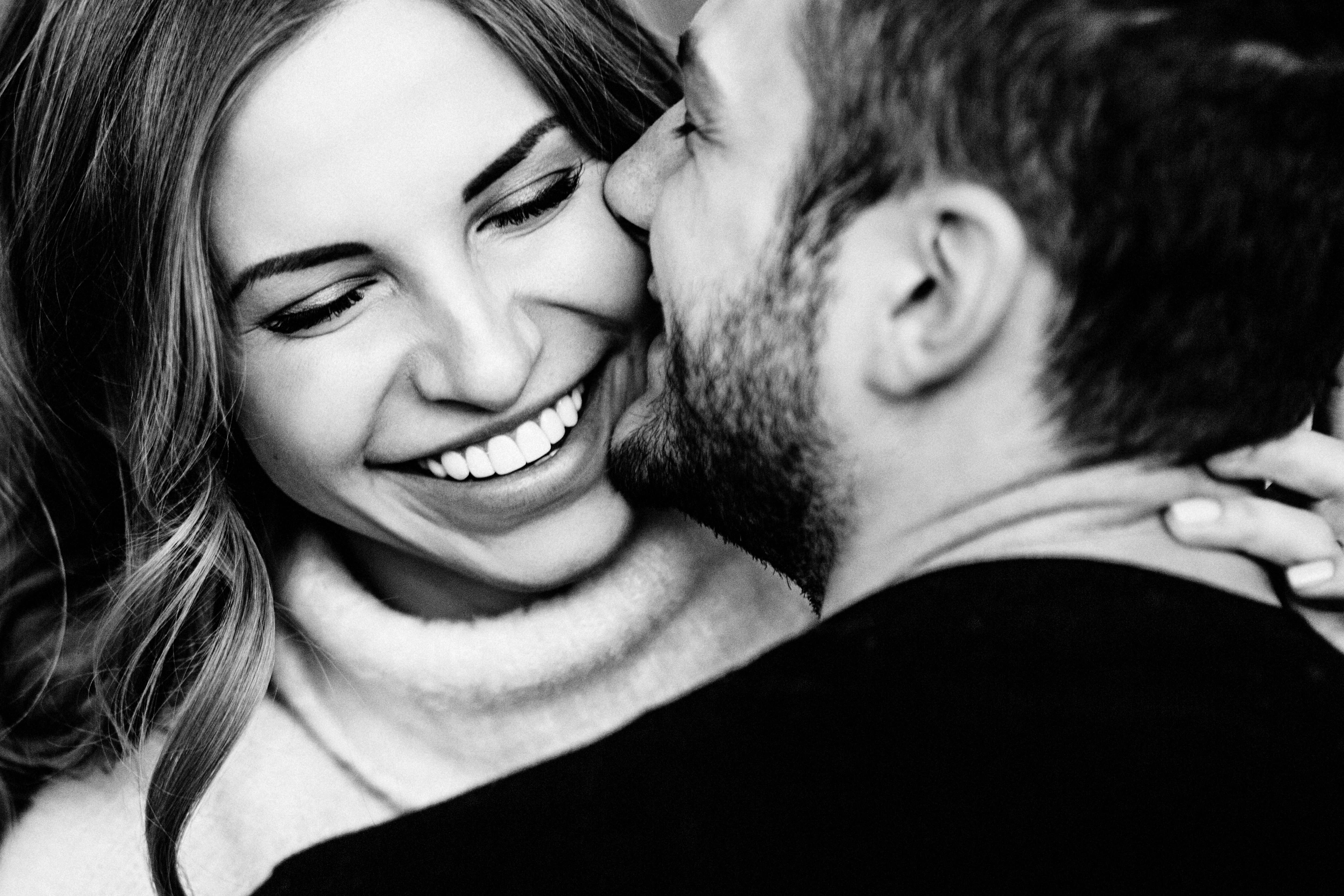 A close-up of a couple smiling playfully in an embrace | Source: Shutterstock