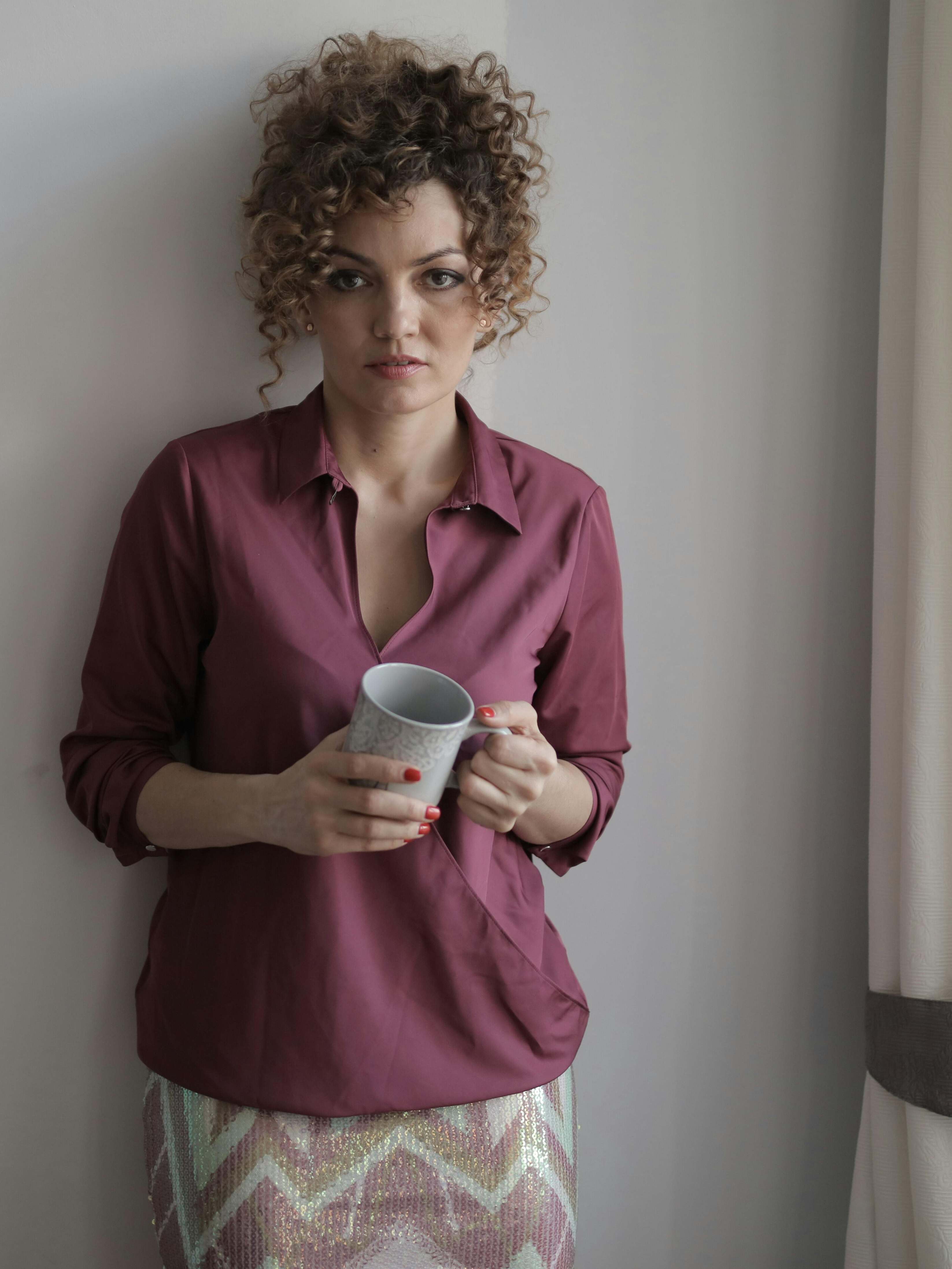 A woman standing with her back to the wall in a living room | Source: Pexels