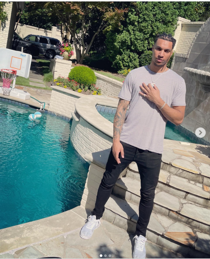 Brandon Clarke poses beside a backyard swimming pool while wearing a striped T-shirt, black jeans, and gray sneakers. | Source: Instagram/brandon_clarke23