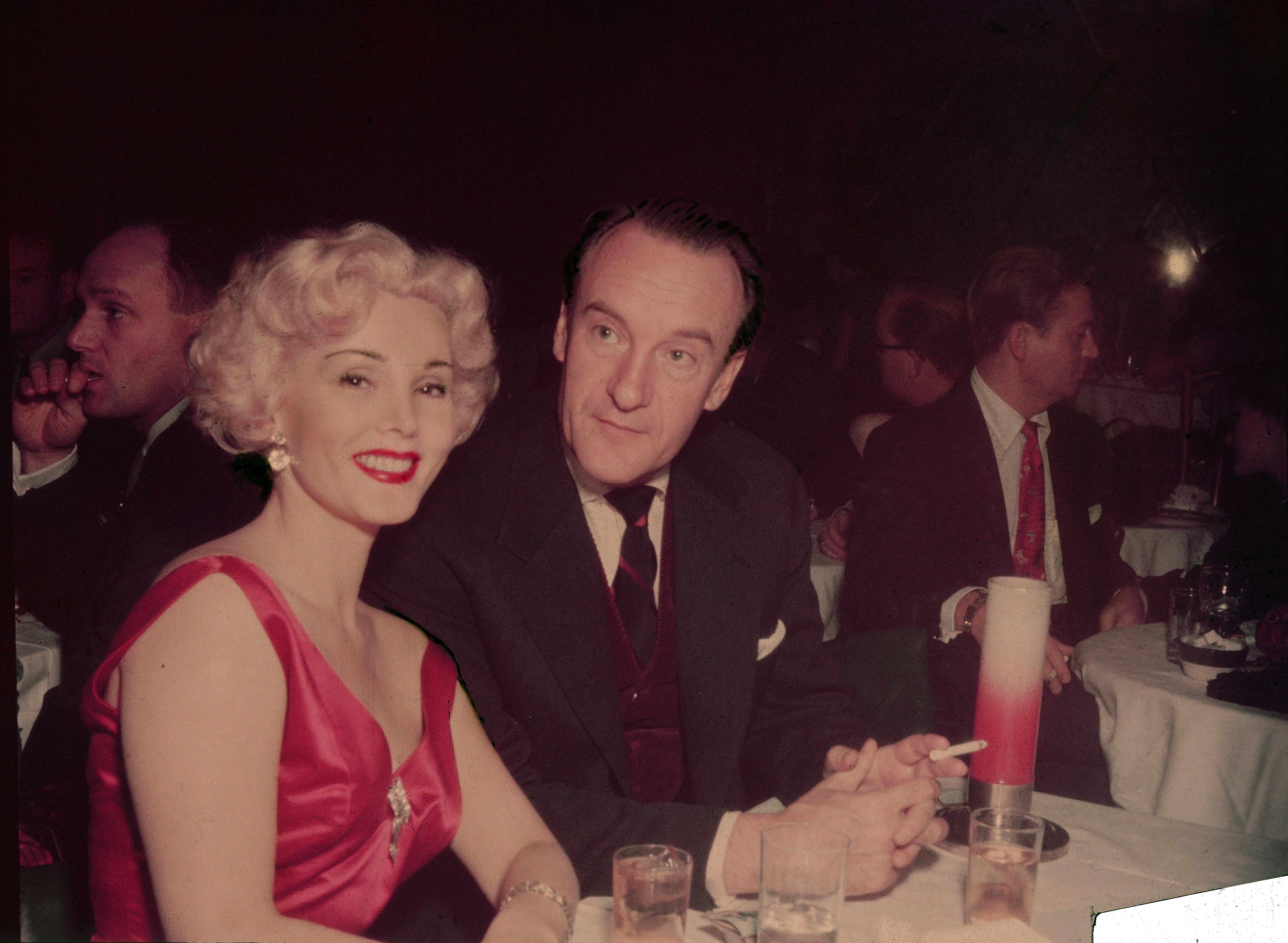 Zsa Zsa Gabor smiles sitting at a table with her husband, British actor George Sanders in the 1950s | Photo: Getty Images