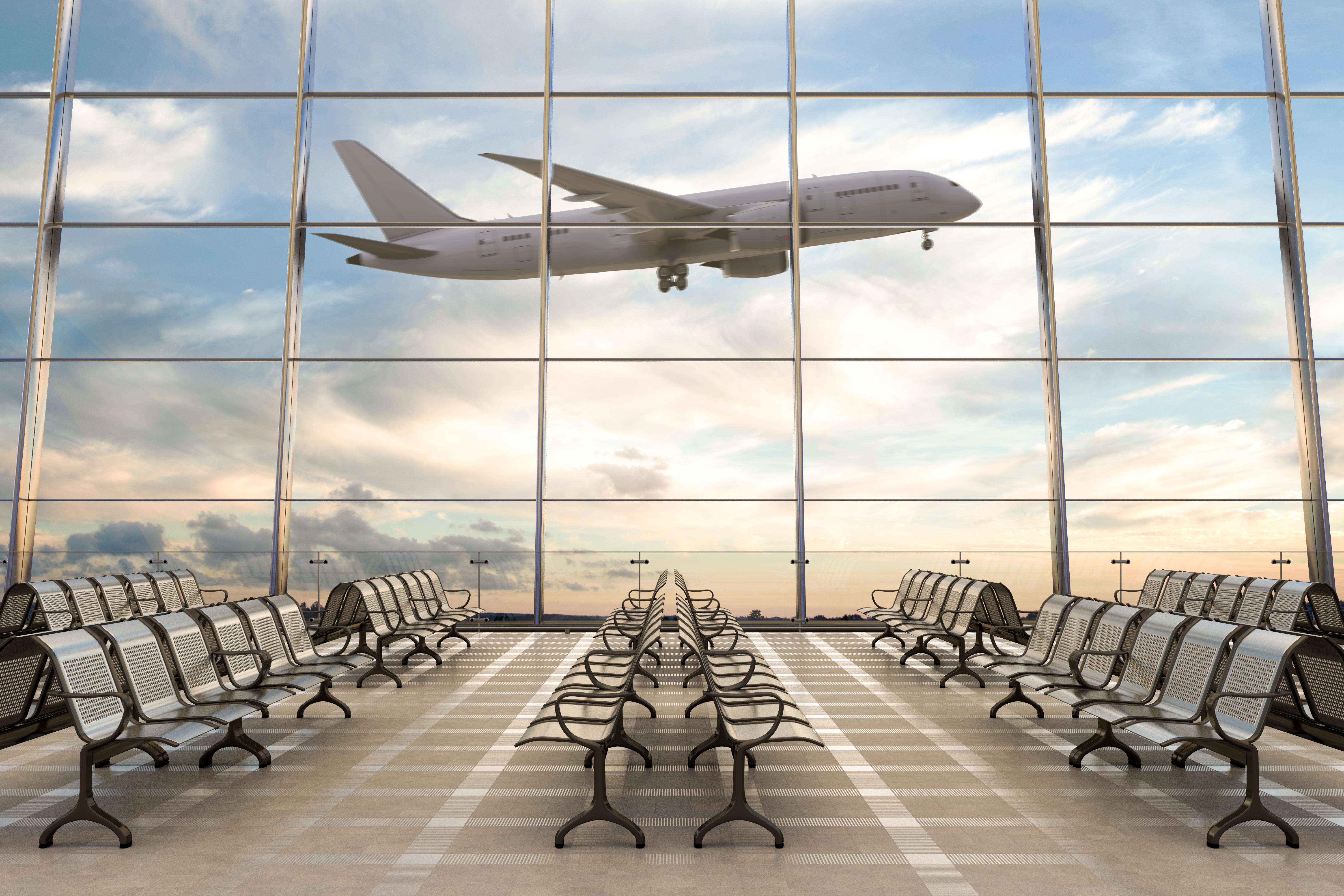 A plane taking off as seen through an airport window | Source: Shutterstock