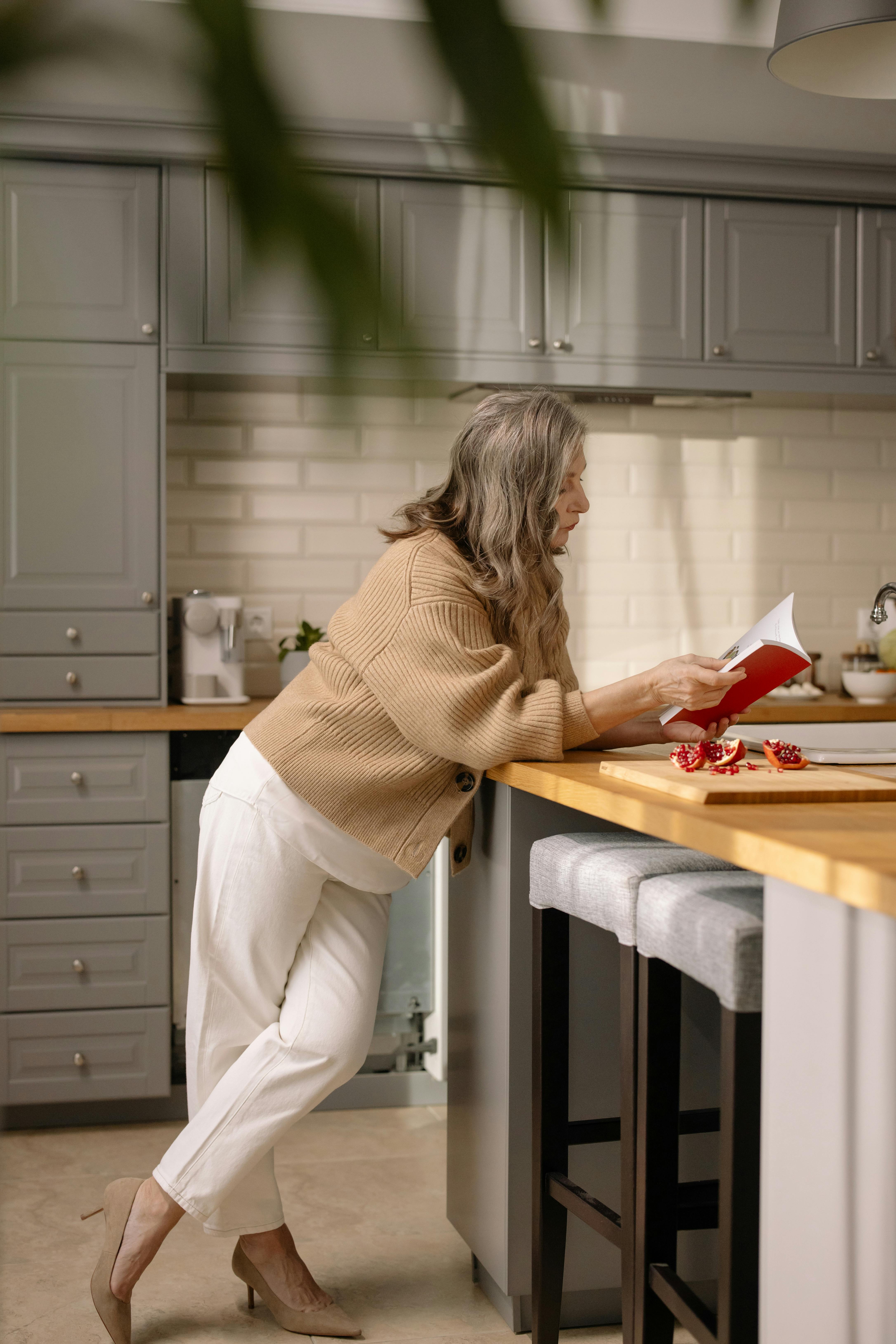 A woman reading in the kitchen | Source: Pexels