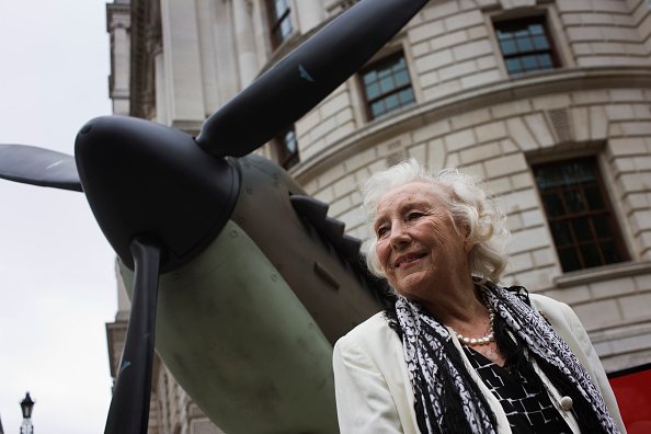 Dame Vera Lynn fait une apparition près d'une réplique d'avion de chasse lors du 70e anniversaire de la bataille d'Angleterre de la Seconde Guerre mondiale. |Photo : Getty Images. Dame Vera Lynn fait une apparition près d'une réplique d'avion de chasse lors du 70e anniversaire de la bataille d'Angleterre de la Seconde Guerre mondiale. |Photo : Getty Images.