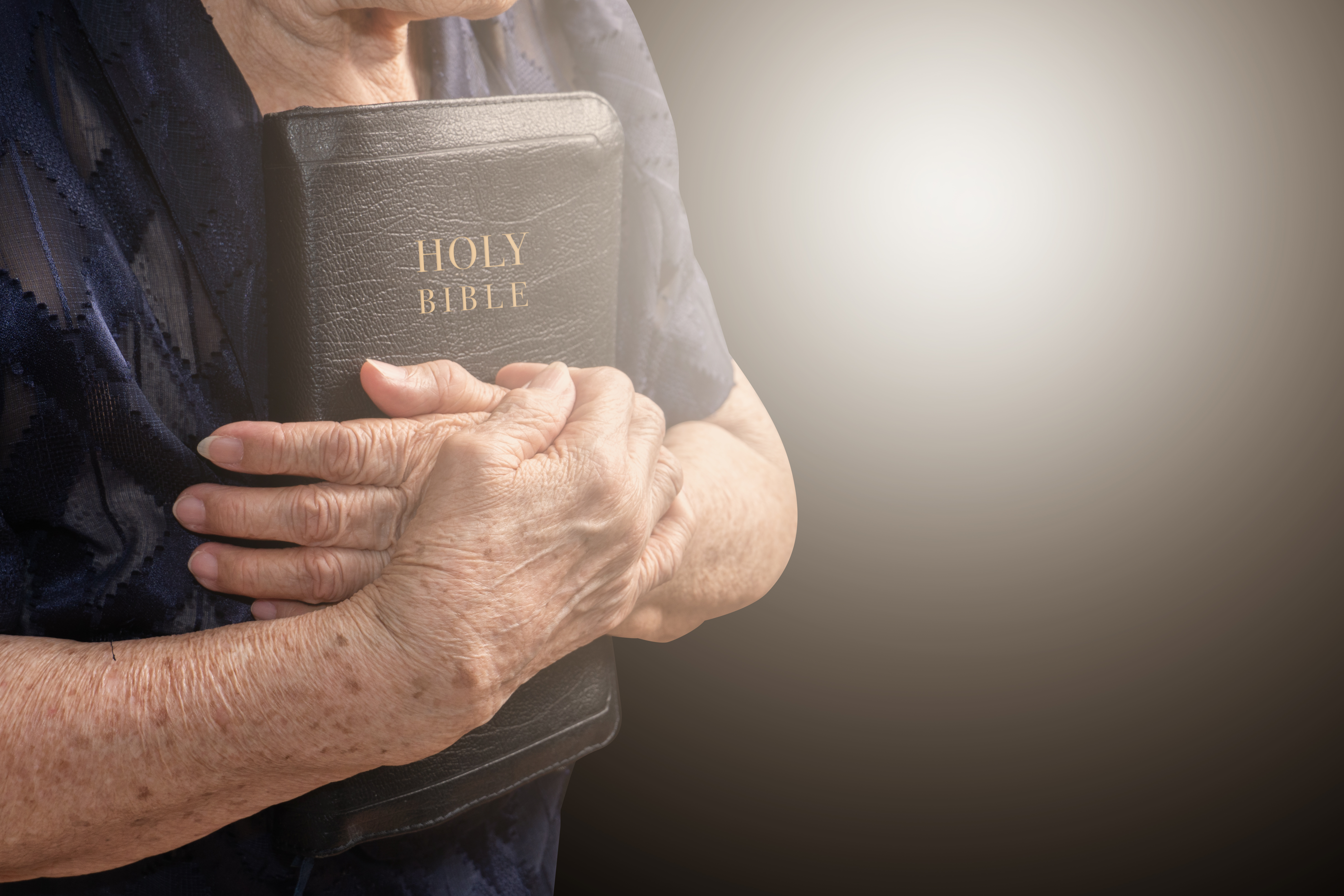 Older woman holding a bible | Source: Shutterstock