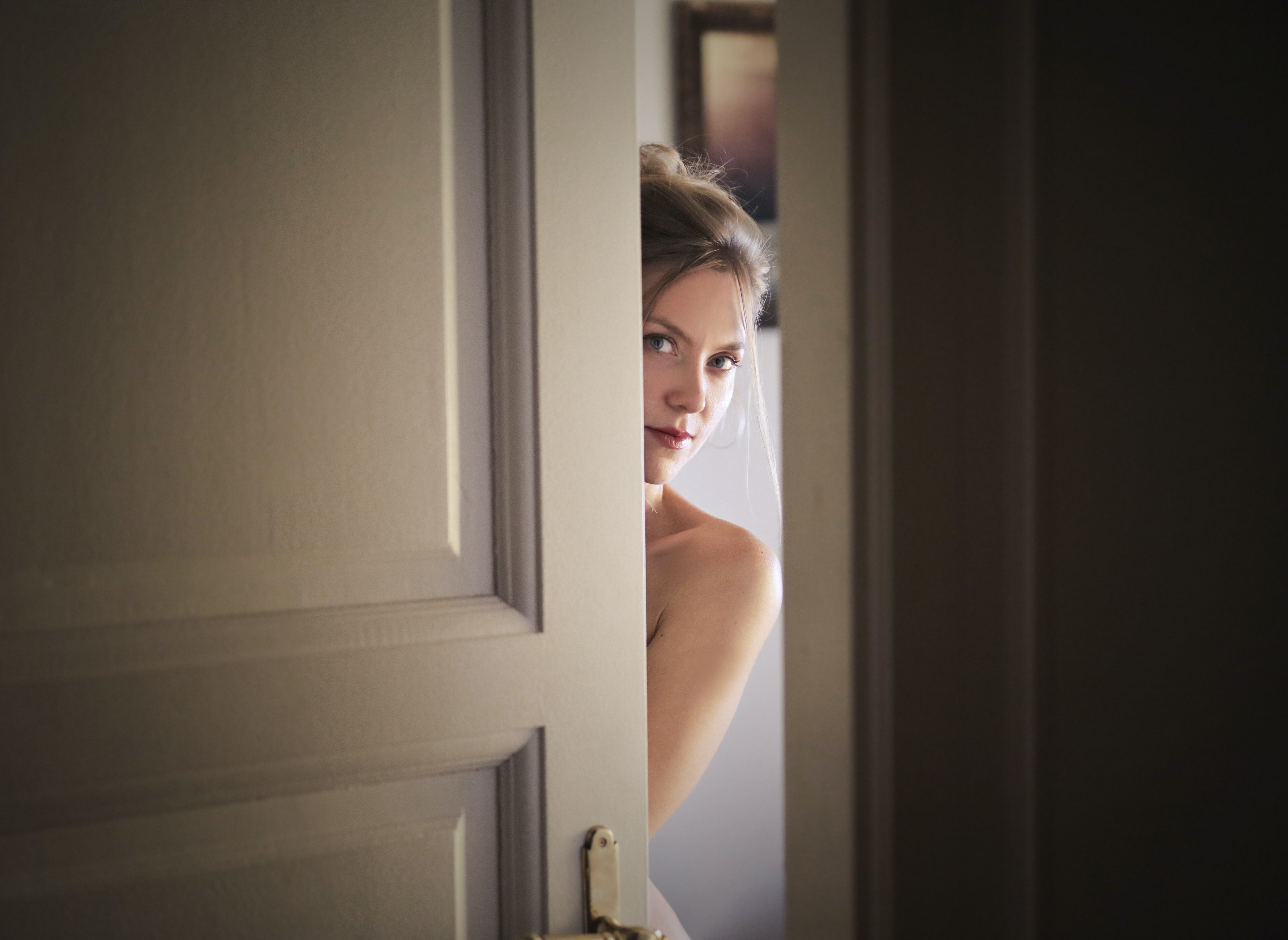 Mujer joven abre su puerta. | Foto: Pexels