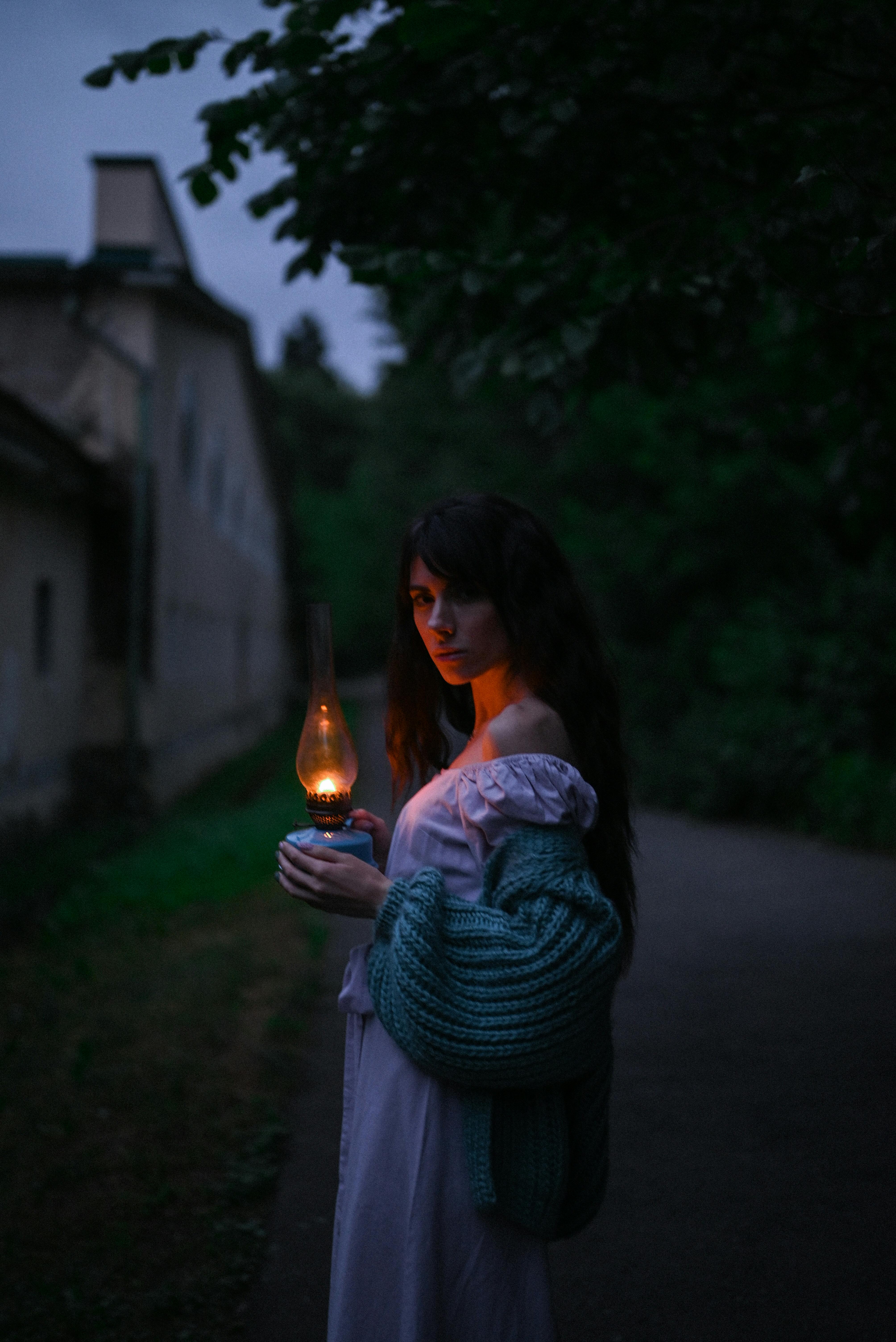 Woman with an old kerosene lamp in the dark | Source: Pexels