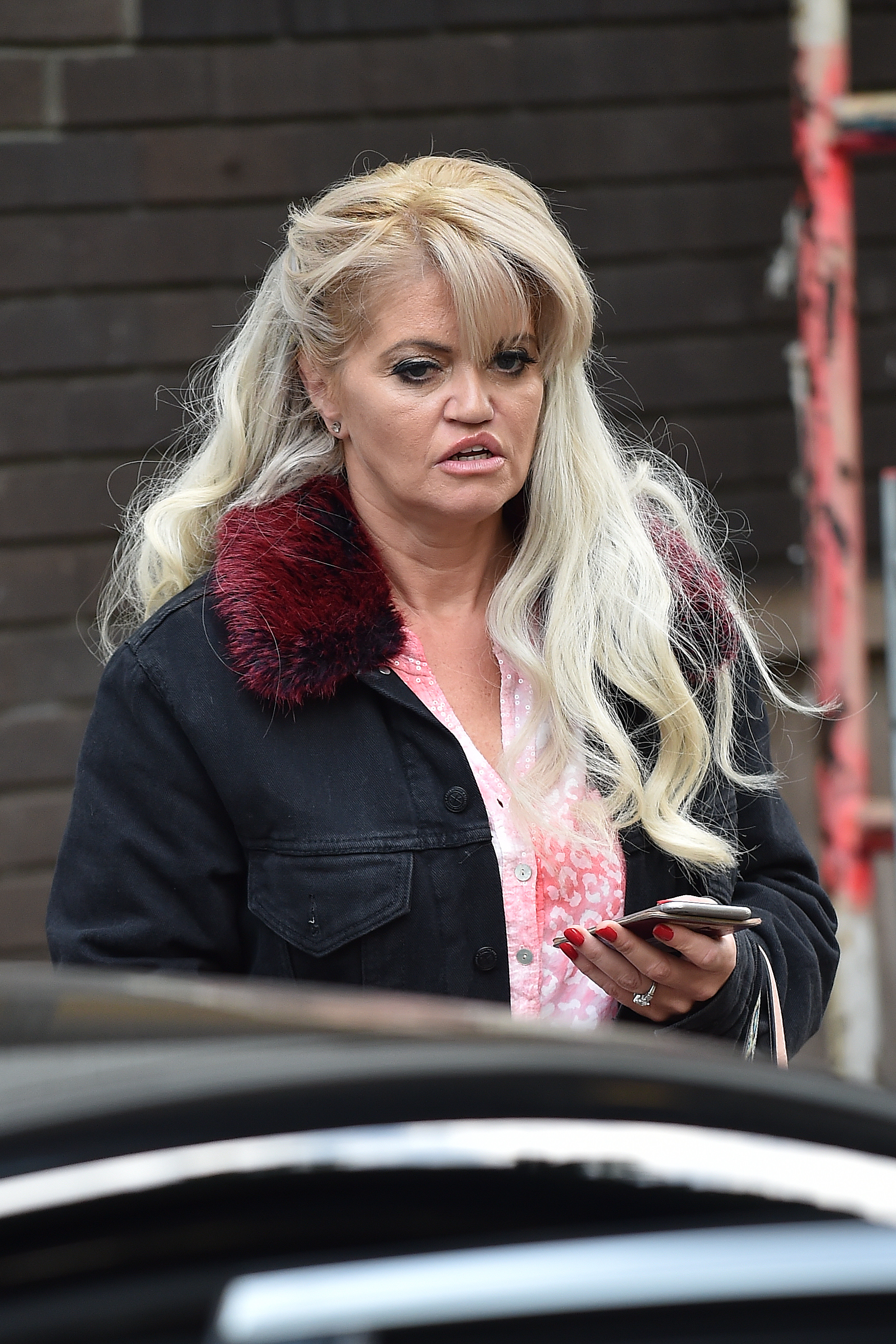 Caught on the move: Westbrook checks her phone on 11 May 2017 as she heads into ITV Studios — bundled up in a casual jacket with a faux-fur collar and an air of quiet focus.