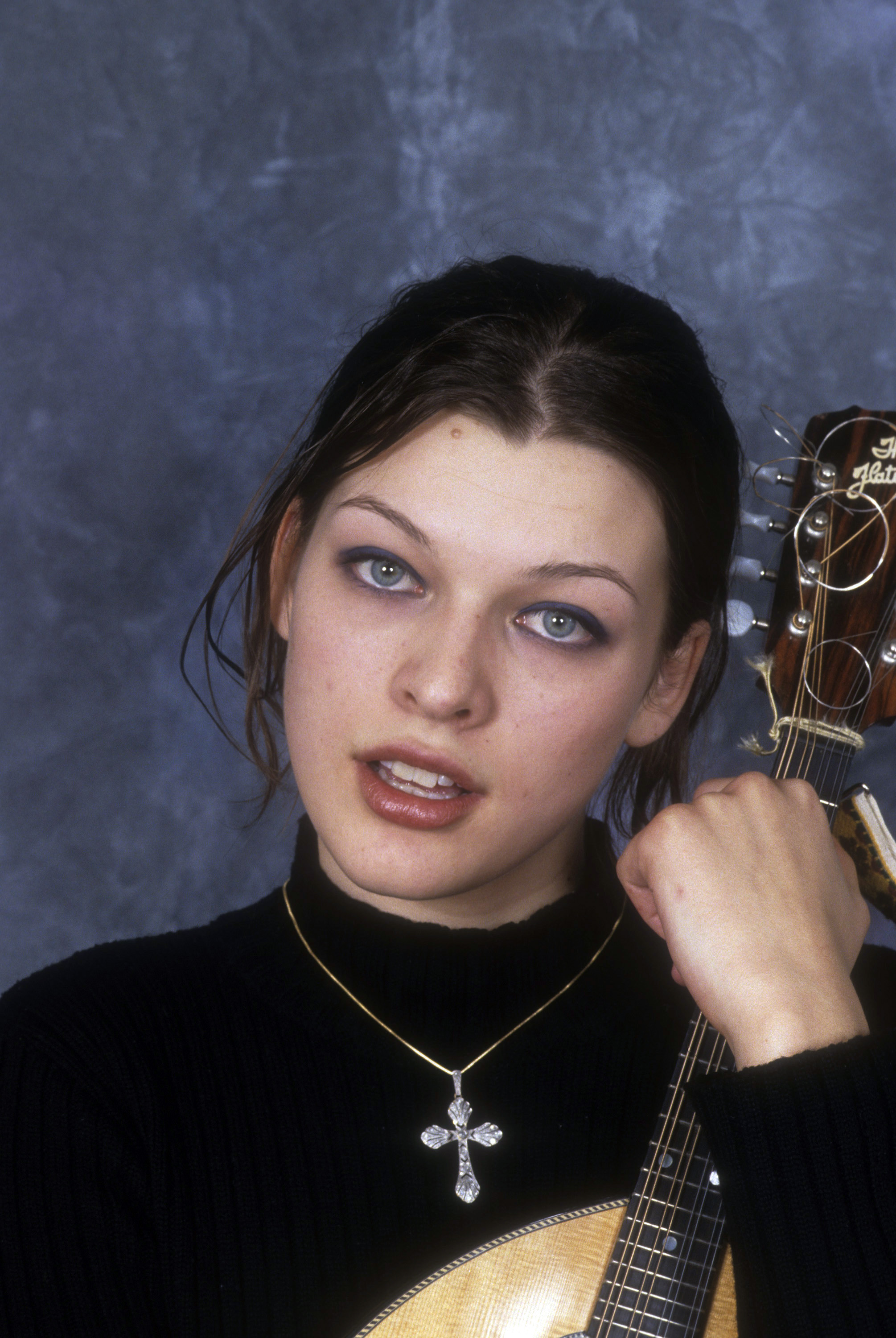 Milla Jovovich appears with her Flatiron Mandolin poses for a portrait on March 10, 1994 in New York City | Source: Getty Images