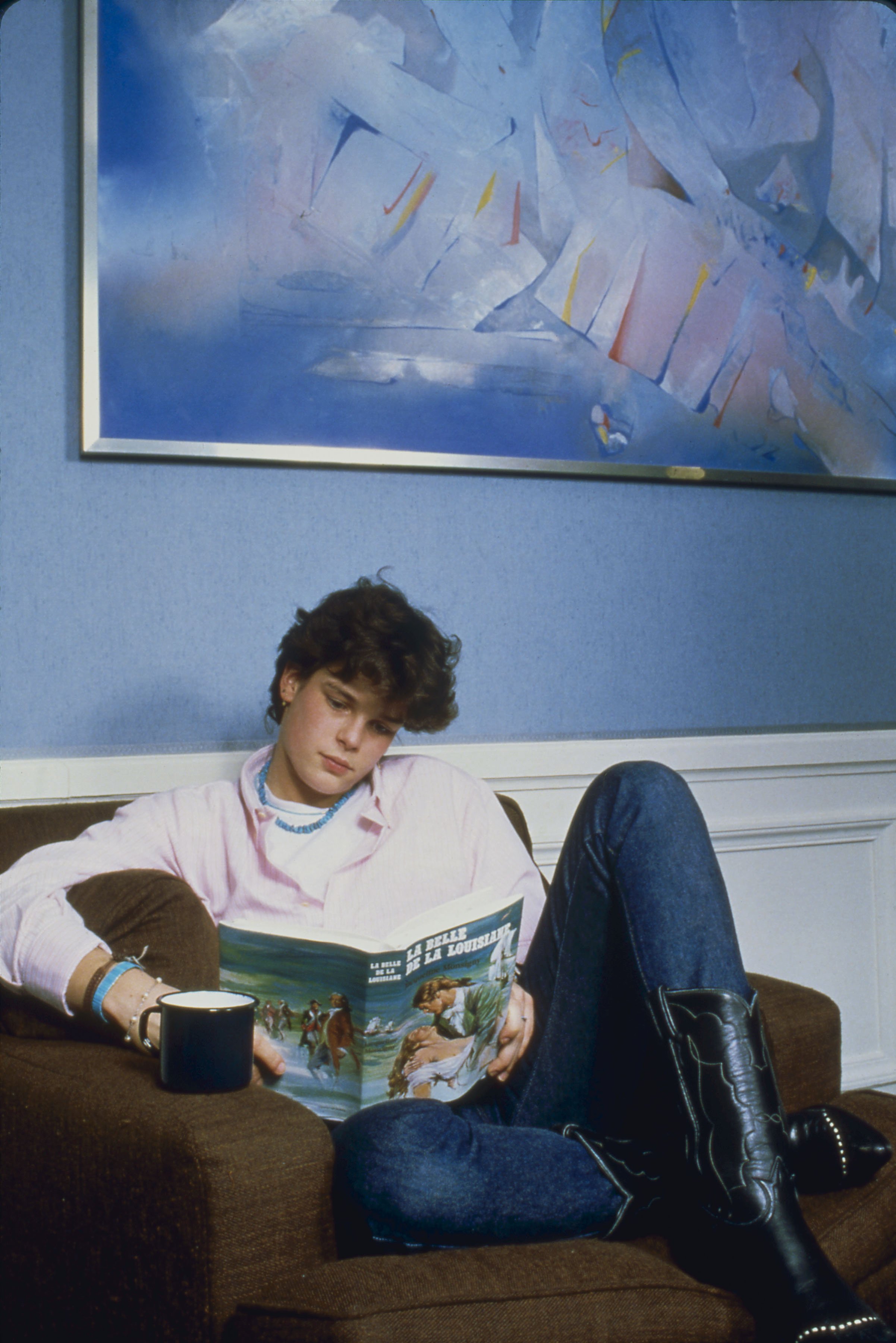 Princess Stephanie reading a book while sitting on a coach with her legs crossed. / Source: Getty Images