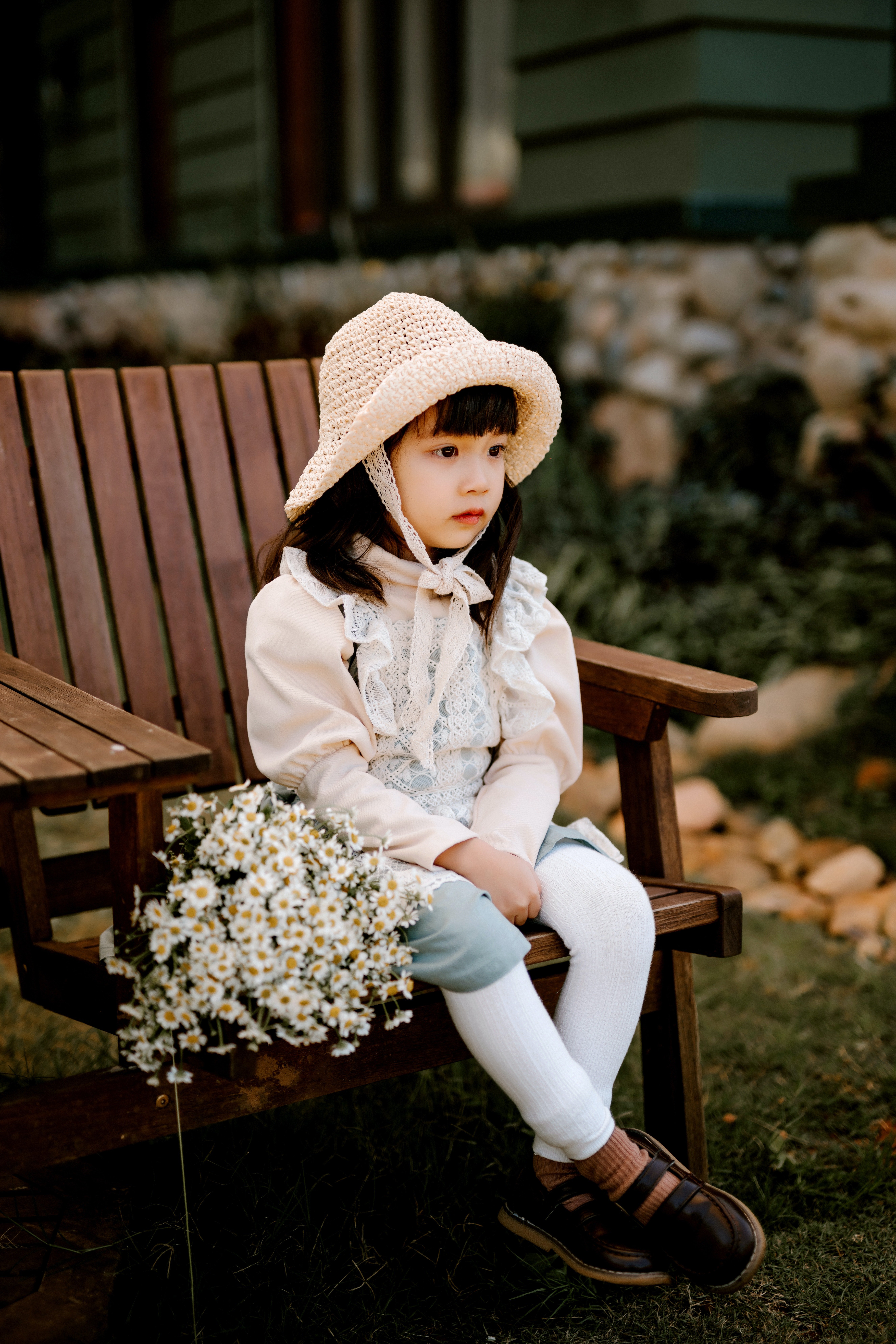Pequeña niña sentada en un banco de madera. | Foto: Pexels