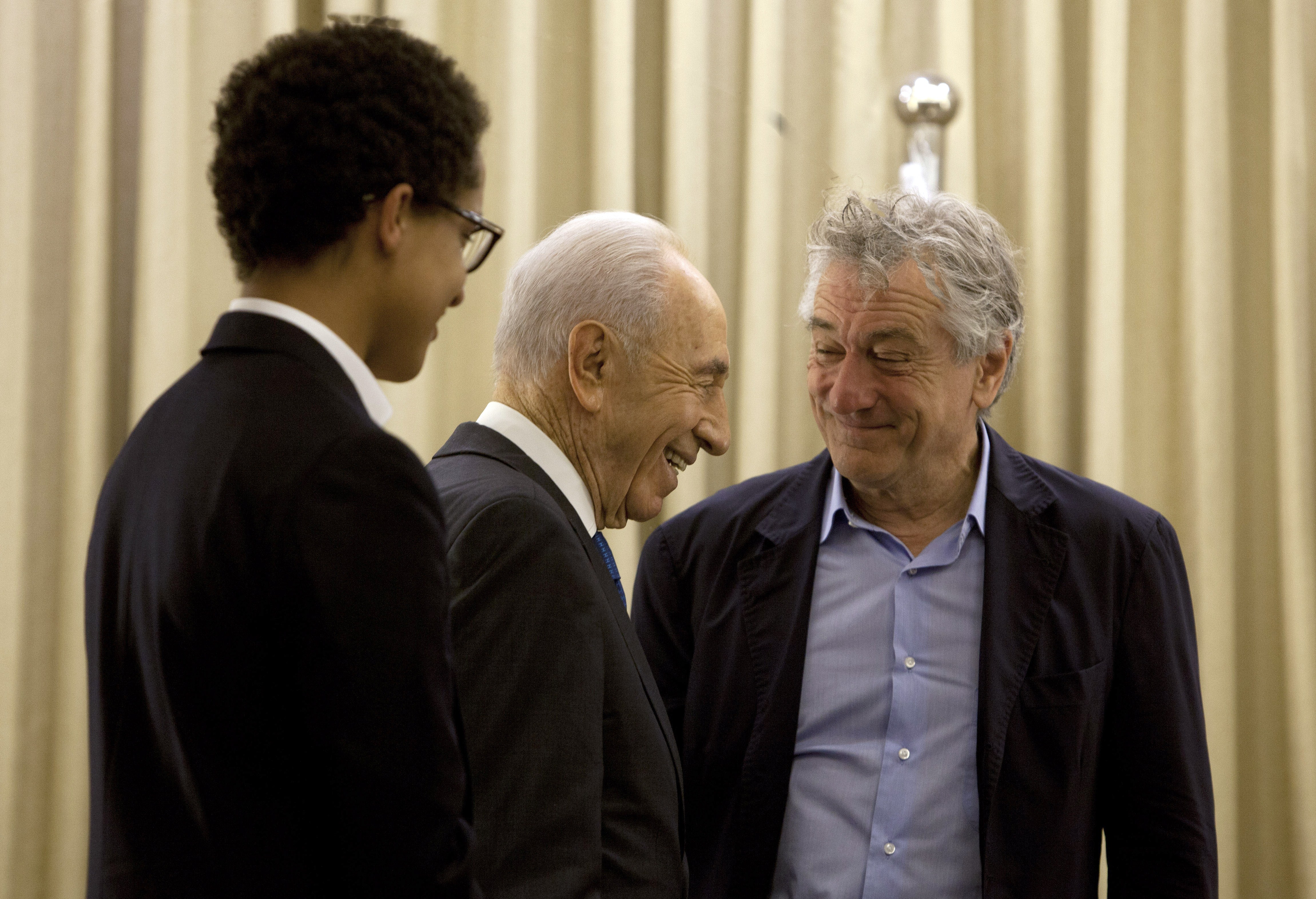 El presidente de Israel, Shimon Peres, pasa junto al actor estadounidense Robert De Niro y su hijo Julian Henry De Niro (I) durante su reunión en la residencia del presidente en Jerusalén, el 18 de junio de 2013. | Foto: Getty Images