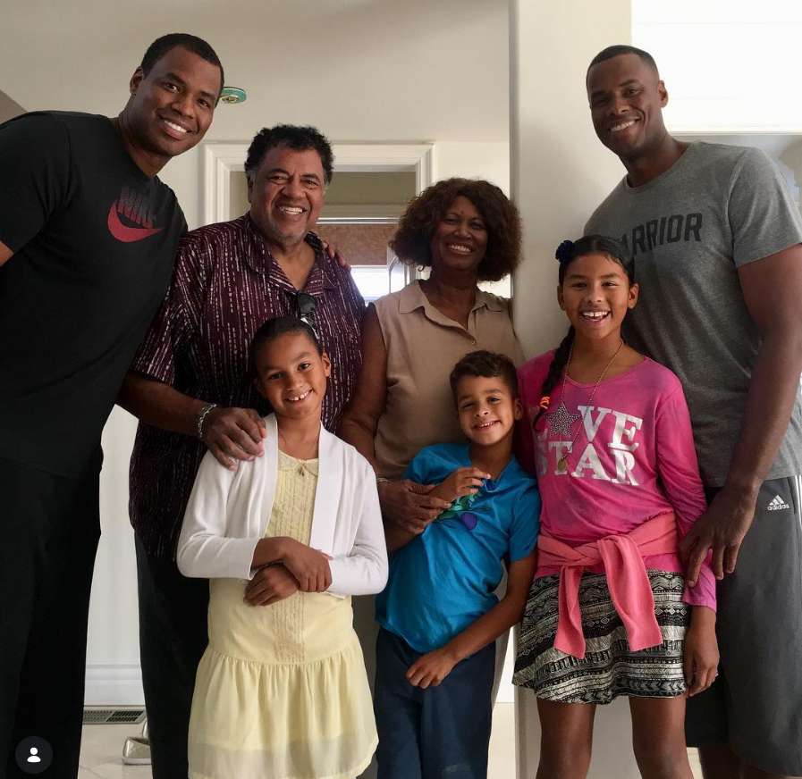 Jason Collins poses with family members inside a home as the group smiles together for a cheerful family portrait featuring both adults and children gathered closely side by side. | Source: Instagram/jasoncollins_98