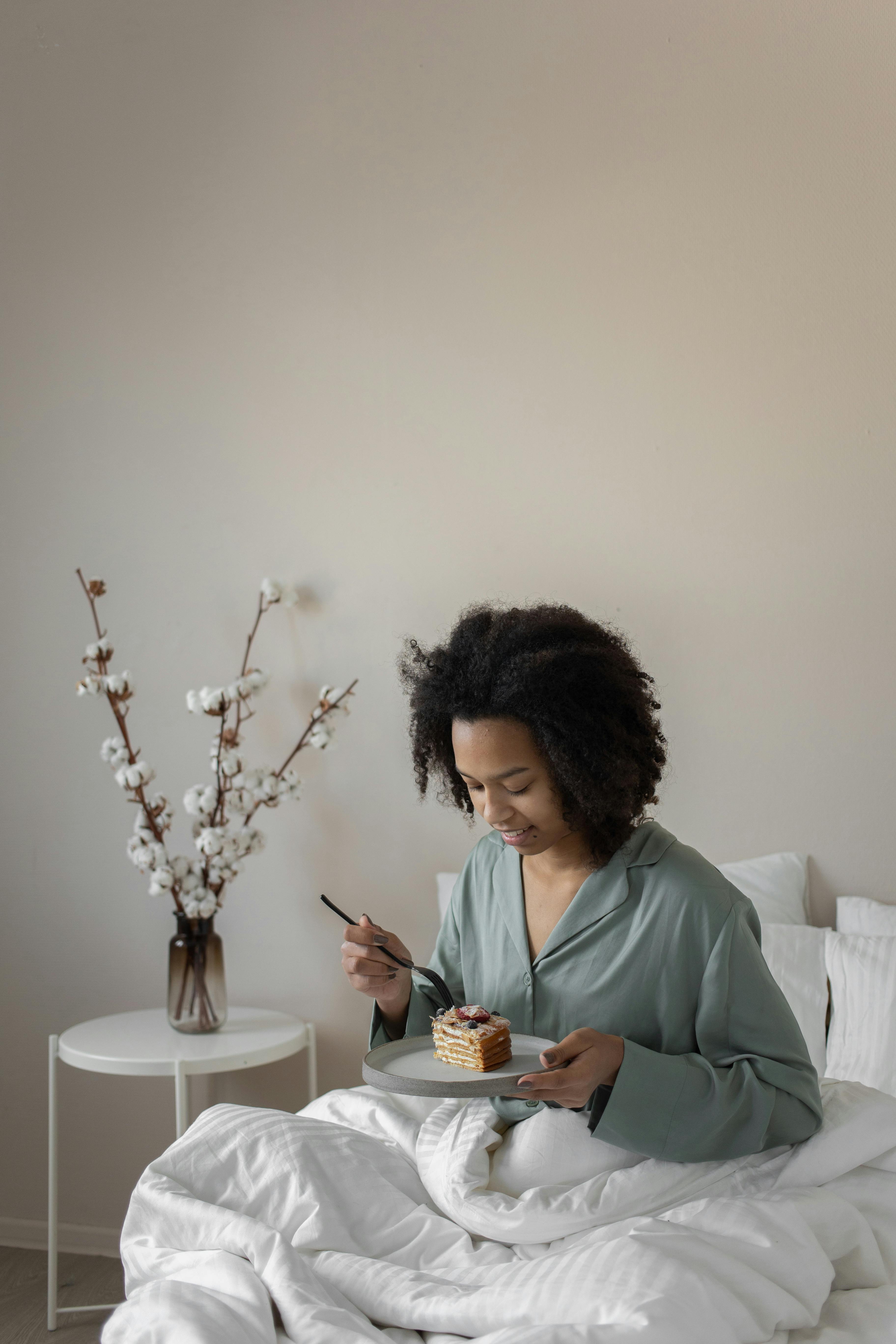 A woman eating in bed | Source: Pexels