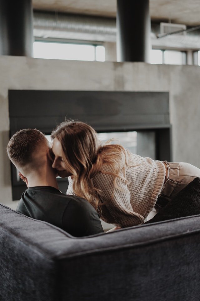 Couple whispering in living room | Source: Unsplash