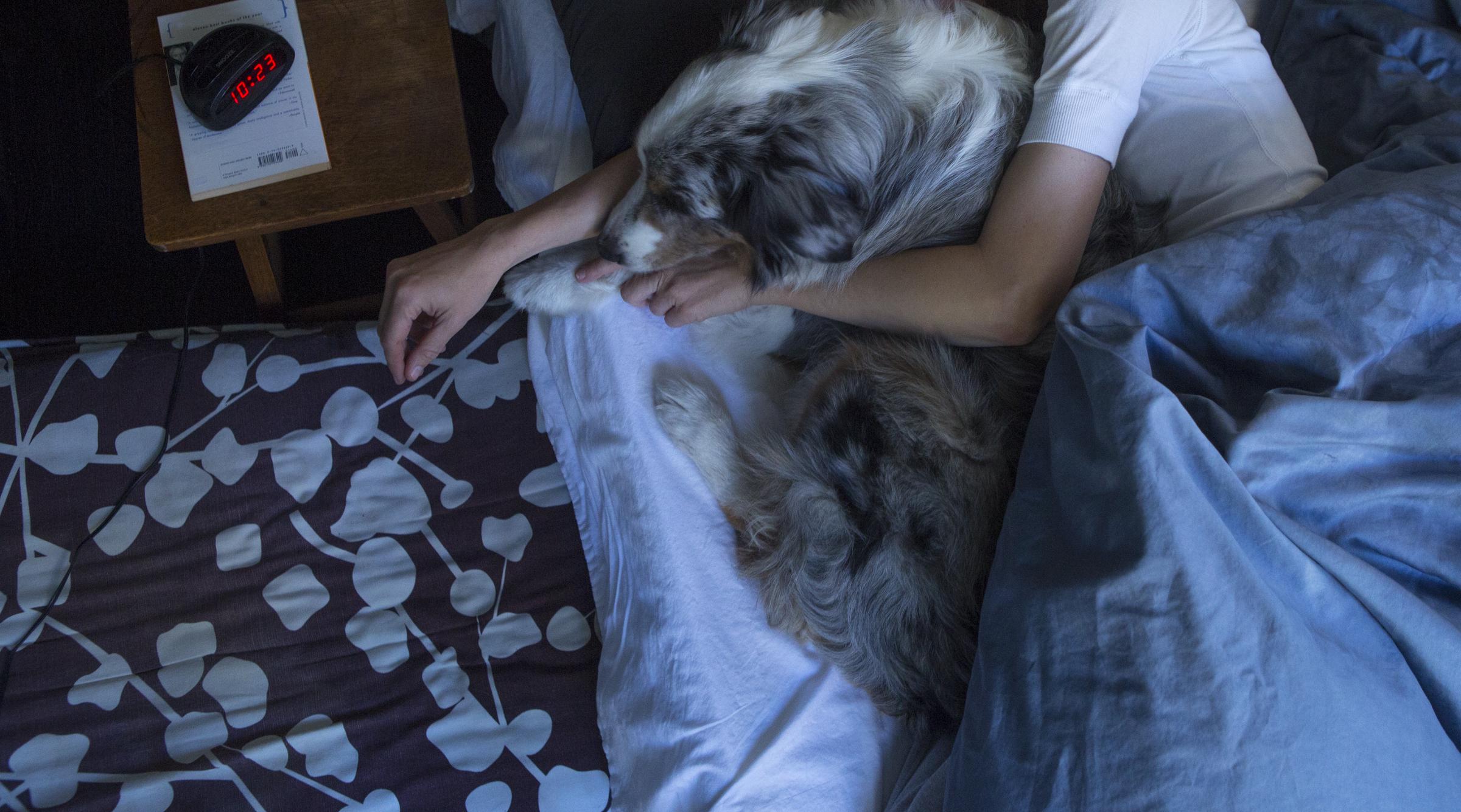 A woman sleeping with her dog | Source: Getty Images