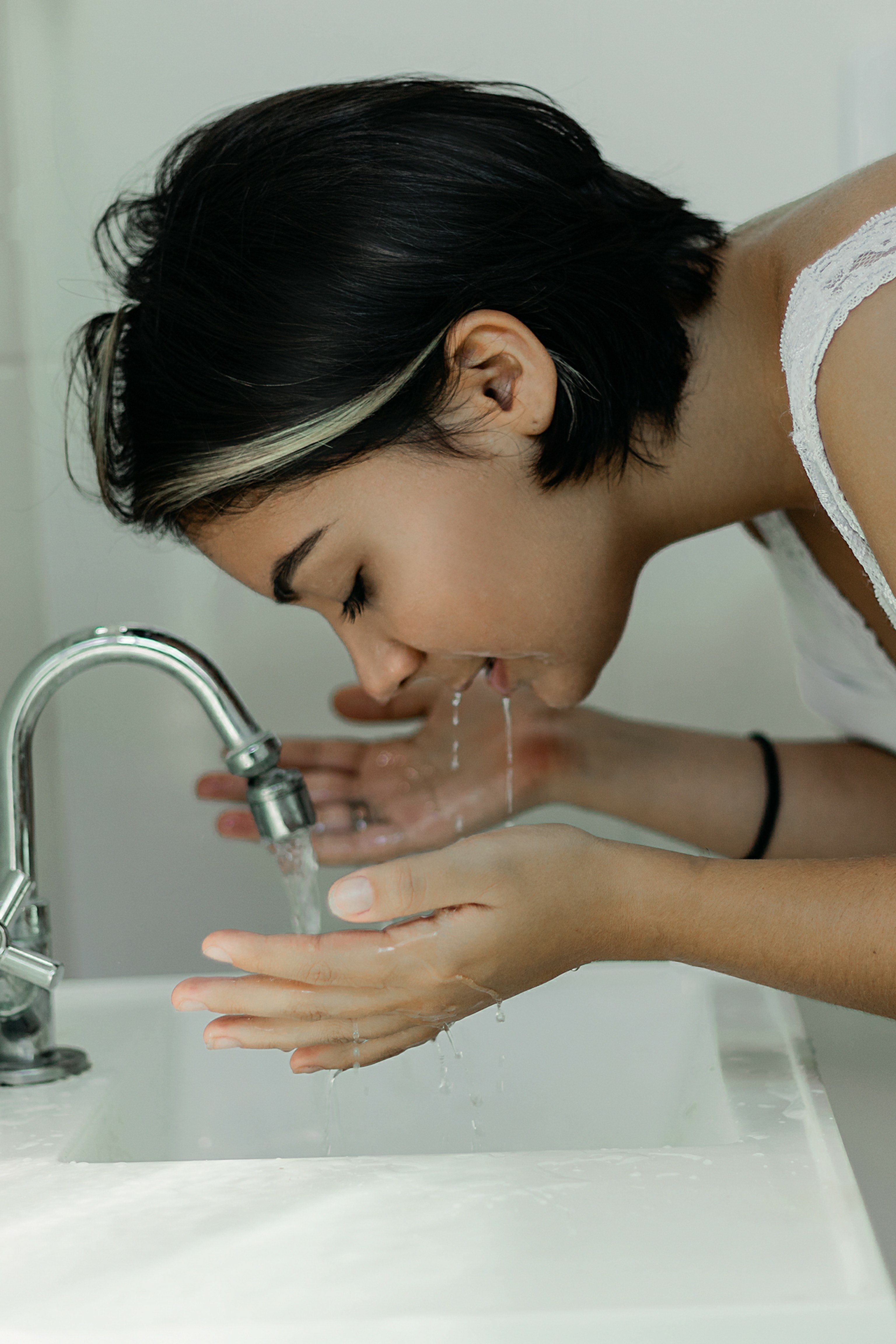 Une femme lavant son visage. | Photo : Pexels