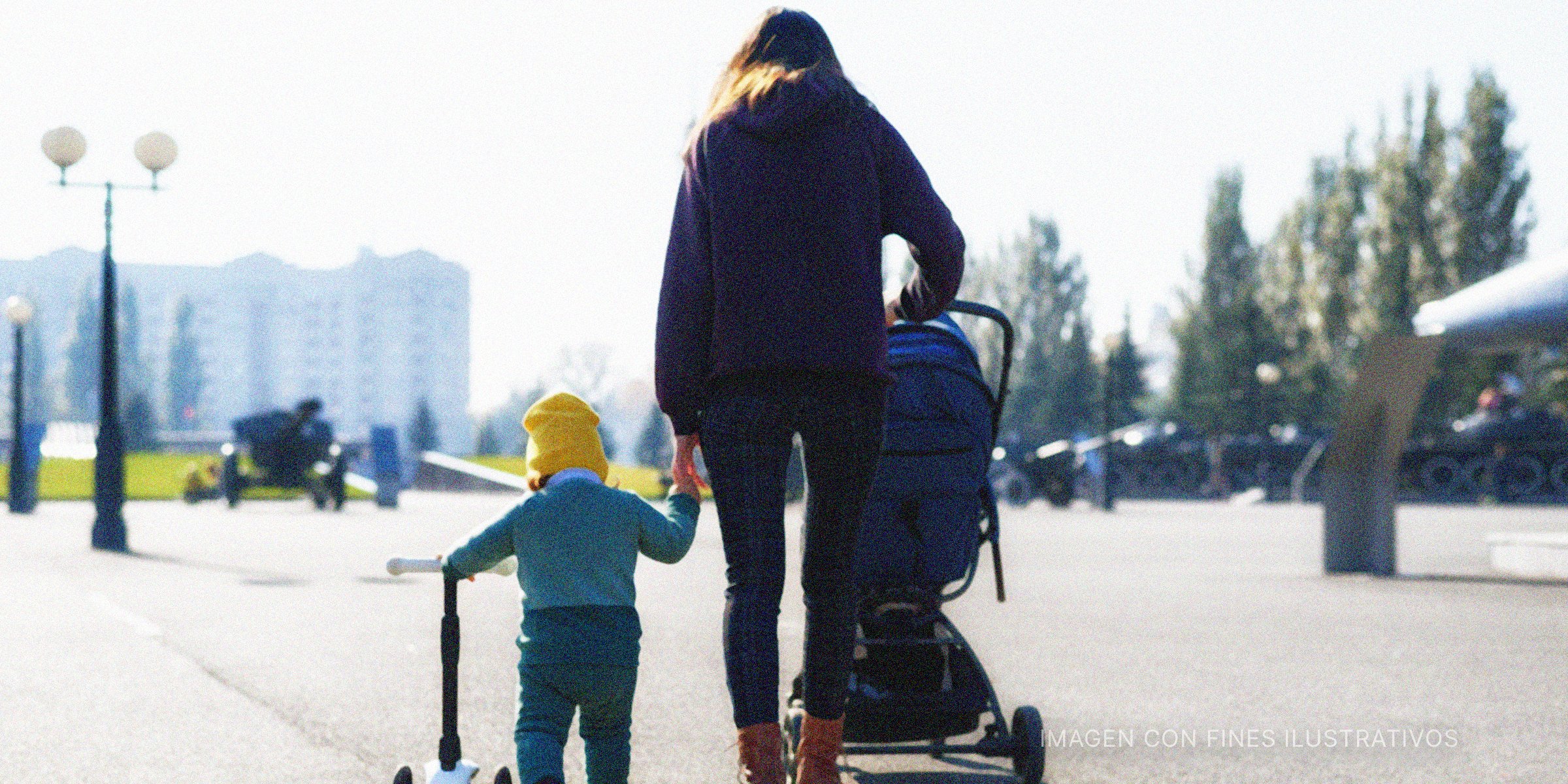 Mujer caminando con su hijo y empujando un cochecito. | Foto: Shutterstock