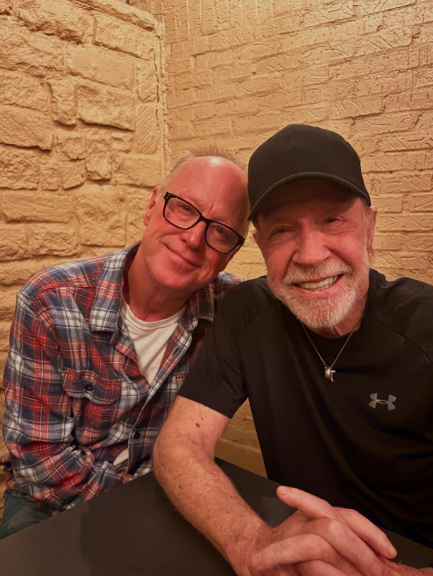 Chuck Norris sits beside his son, Mike Norris, the two leaning in close with easy smiles after a night out together. | Source: Instagram/imvalnorris