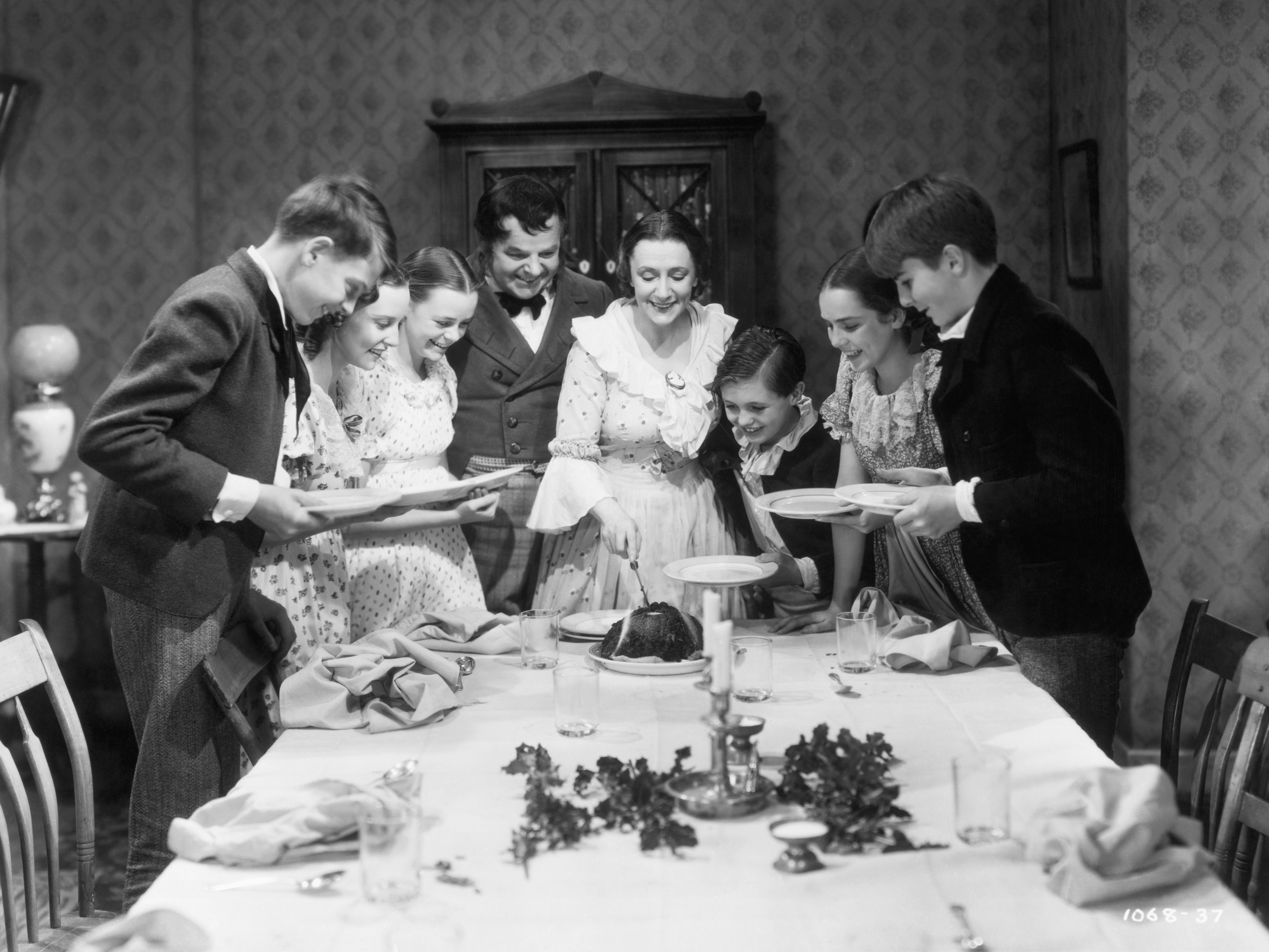 The Cratchit family at Christmas dinner in a scene from "A Christmas Carol," directed by Edwin L. Marin, circa 1938. From third left, June Lockhart, Gene Lockhart, Kathleen Lockhart and Terry Kilburn. | Source: Getty Images