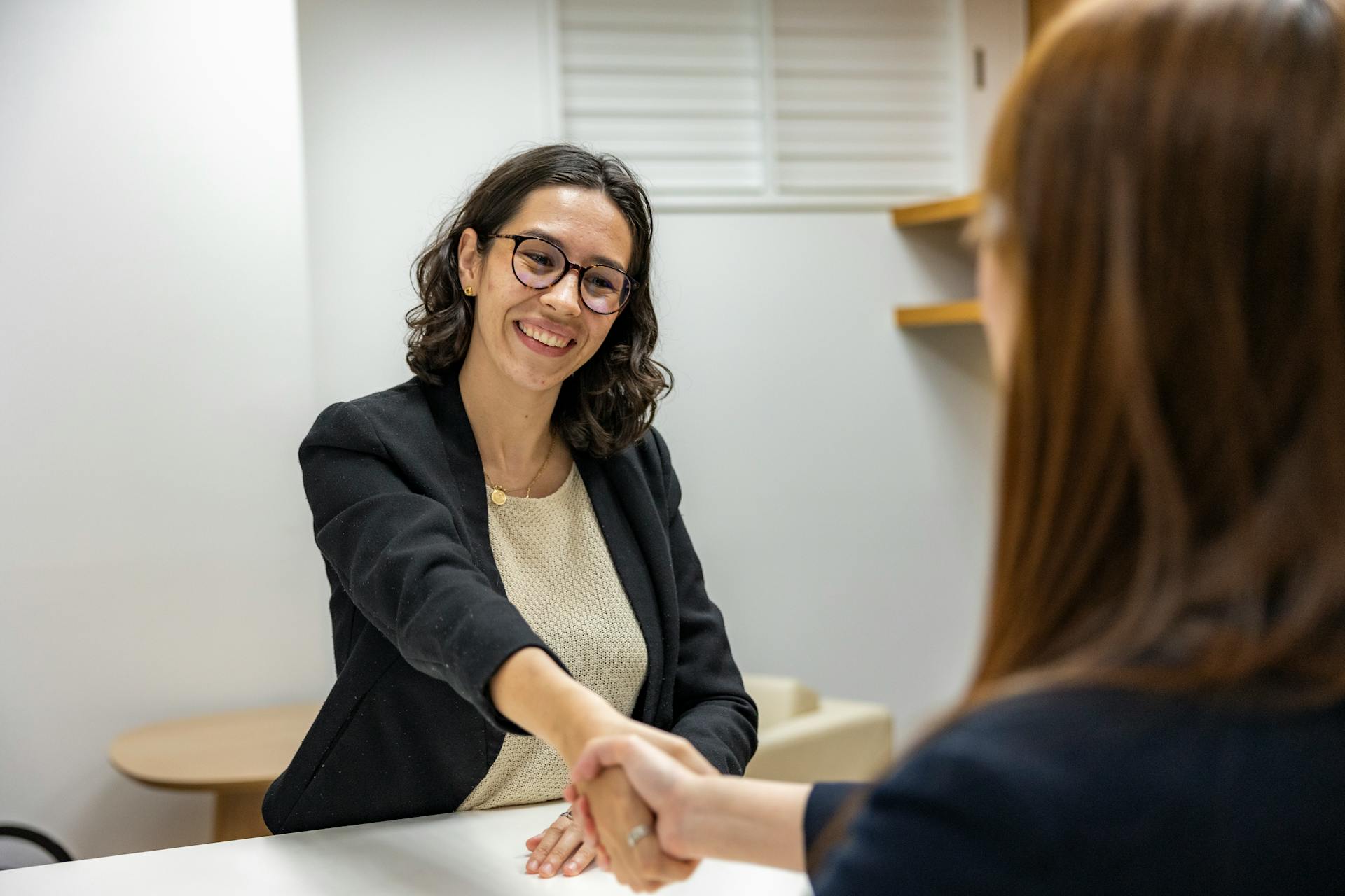 Woman shaking hands in an office | Source: Pexels