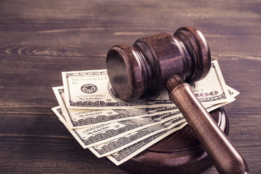 Der Hammer eines Richters auf einigen Dollarnoten. | Foto von: Shutterstock