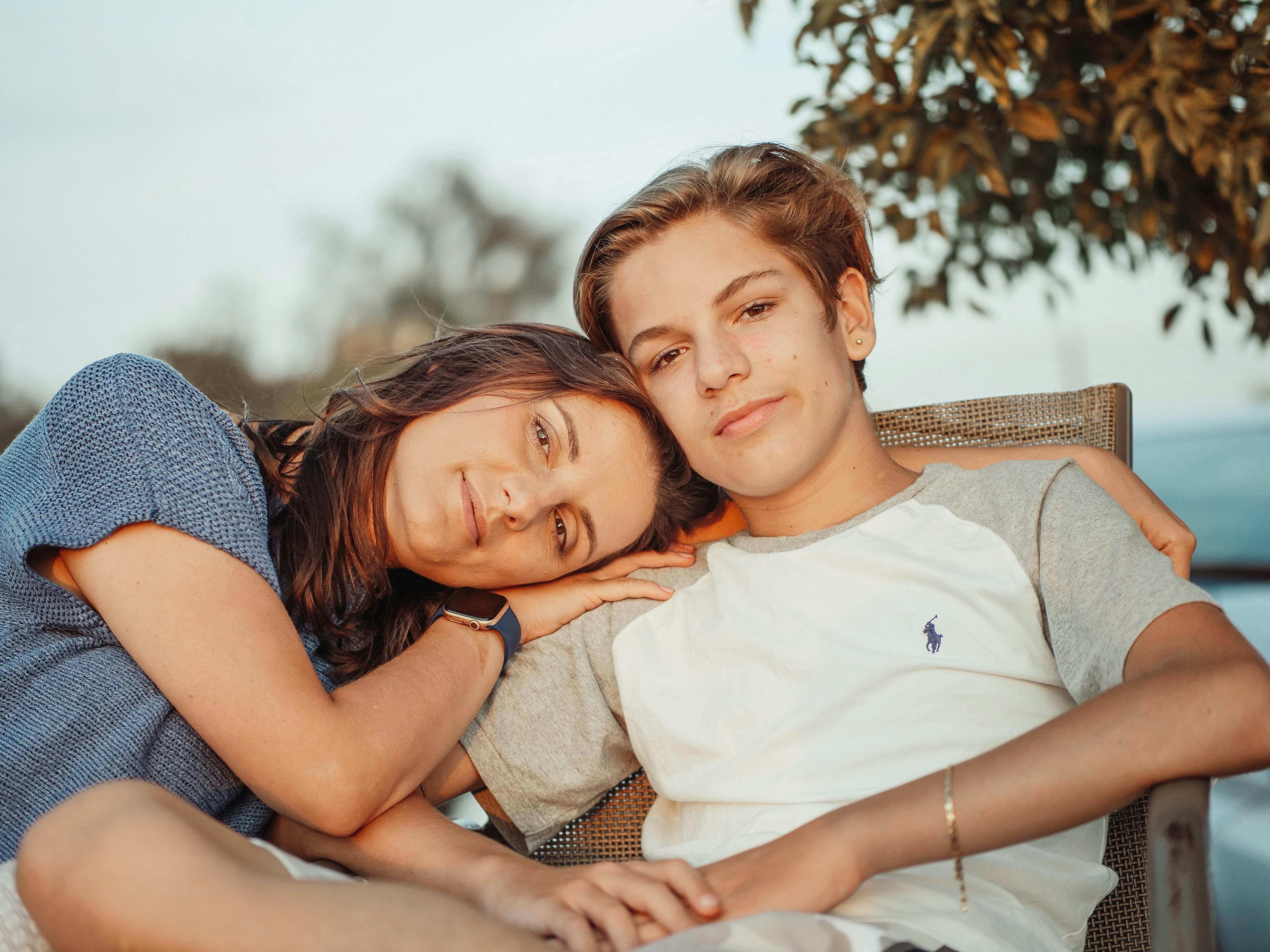 A mother resting her head on her son's shoulder | Source: Pexels