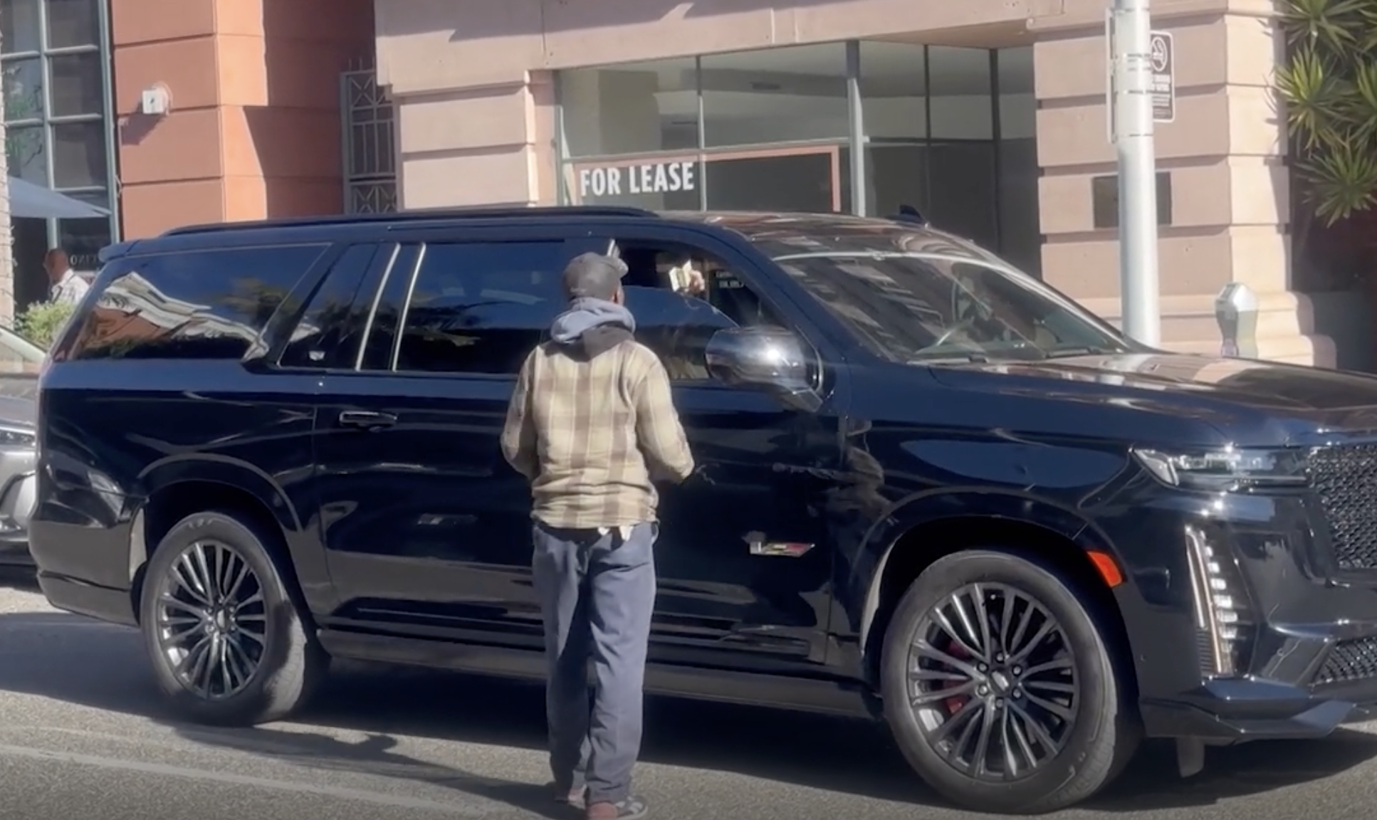 Jennifer Lopez seen inside her SUV moments before handing money to the man outside her window | Source: Youtube/TMZ