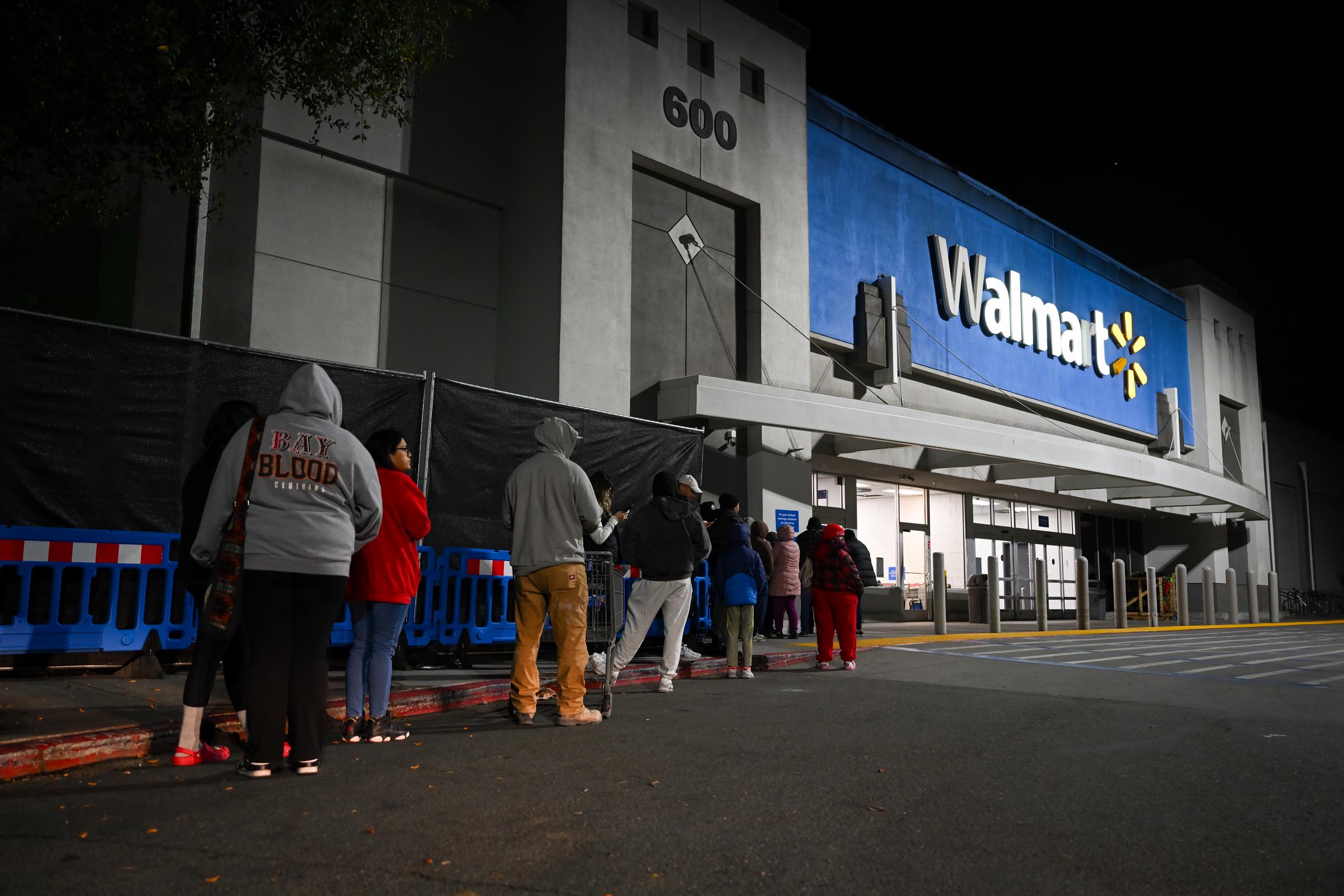 Shopers waiting in line outside a Walmart store in Mountain View, California on November 29, 2024. | Source: Getty Images