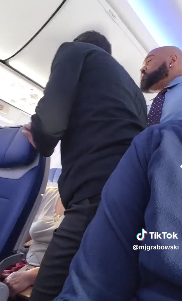 Ein Mann amüsiert sich, während er einen wütenden Passagier aufnimmt, der sich über ein schreiendes Baby auf einem Southwest Airlines-Flug beschwert, während das Flugpersonal versucht, ihn zu beruhigen | Quelle: TikTok/mjgrabowski